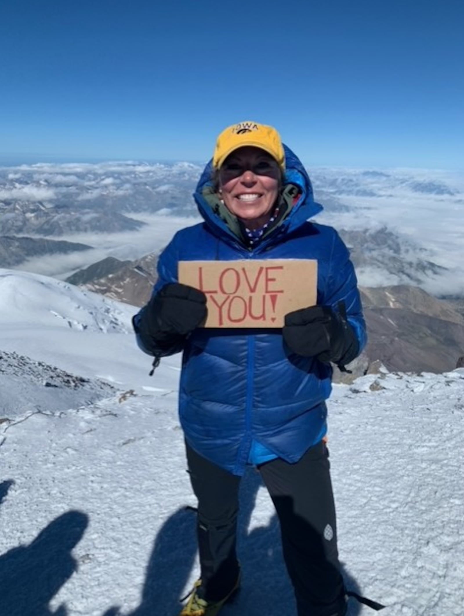 Cheryl Dillin, of Springboro, is a mountain  climber. Here she shows off a "love you sign" and Iowa hat. CONTRIBUTED