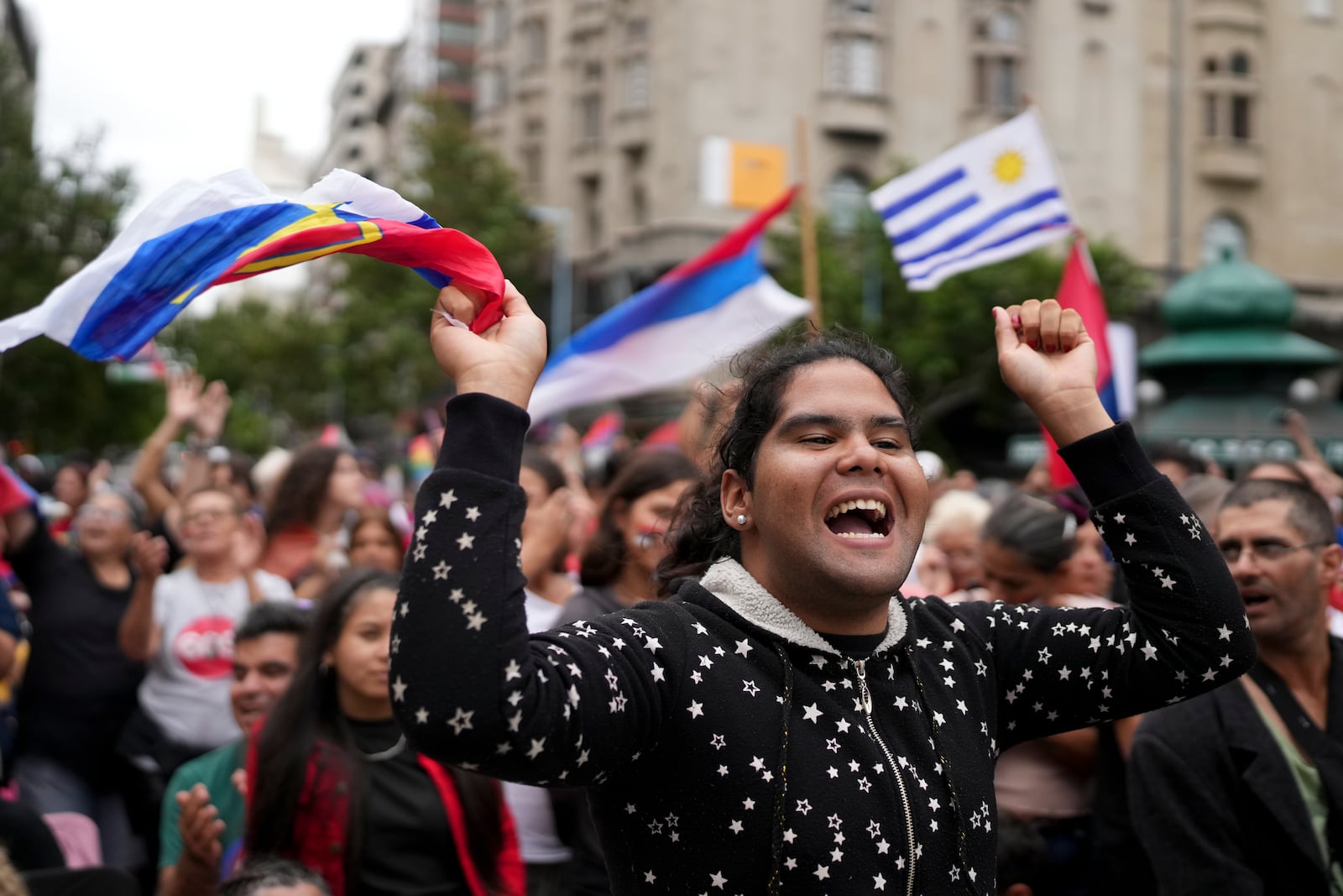 People gather with Uruguay's flags prior to President-elect Yamandu Orsi's swearing-in ceremony, on Inauguration Day in Montevideo, Uruguay, Saturday, March 1, 2025. (AP Photo/Matilde Campodonico)