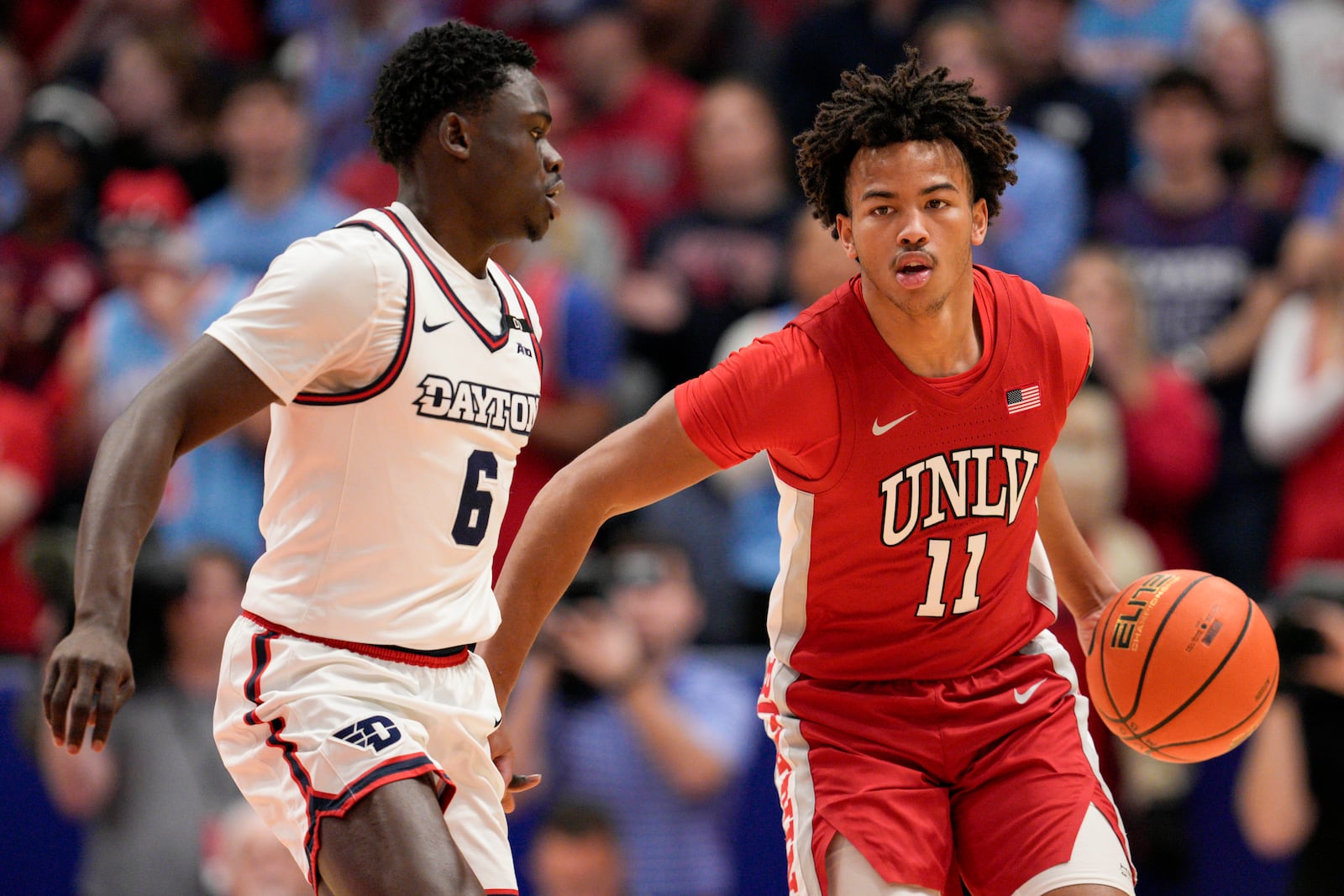 UNLV guard Dedan Thomas Jr. (11) dribbles against Dayton's Enoch Cheeks (6) during the first half of an NCAA college basketball game, Tuesday, Dec. 17, 2024, in Dayton, Ohio. (AP Photo/Jeff Dean)