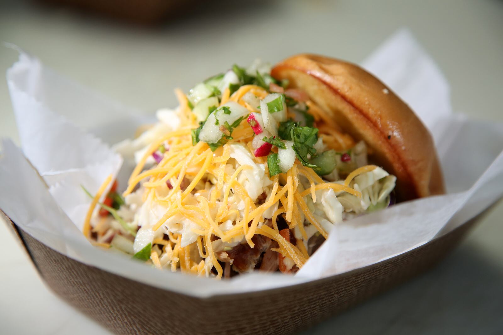 Caption: A popular item sold by the Dayton Urban BBQ food truck is "The Hobo," a sandwich pile high with pulled pork and topped with homemade slaw and a choice of mild or spicy BBQ sauce.  LISA POWELL / STAFF