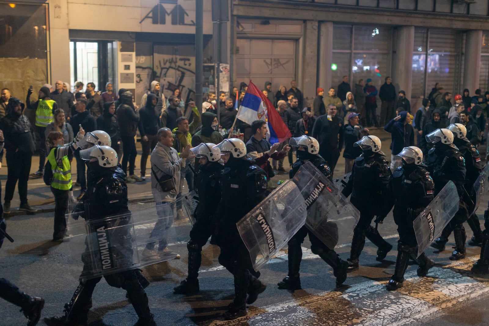 Police in riot gear walk down a street during a major anti-corruption rally led by university students in Belgrade, Serbia, Saturday, March 15, 2025. (AP Photo/Marko Drobnjakovic)