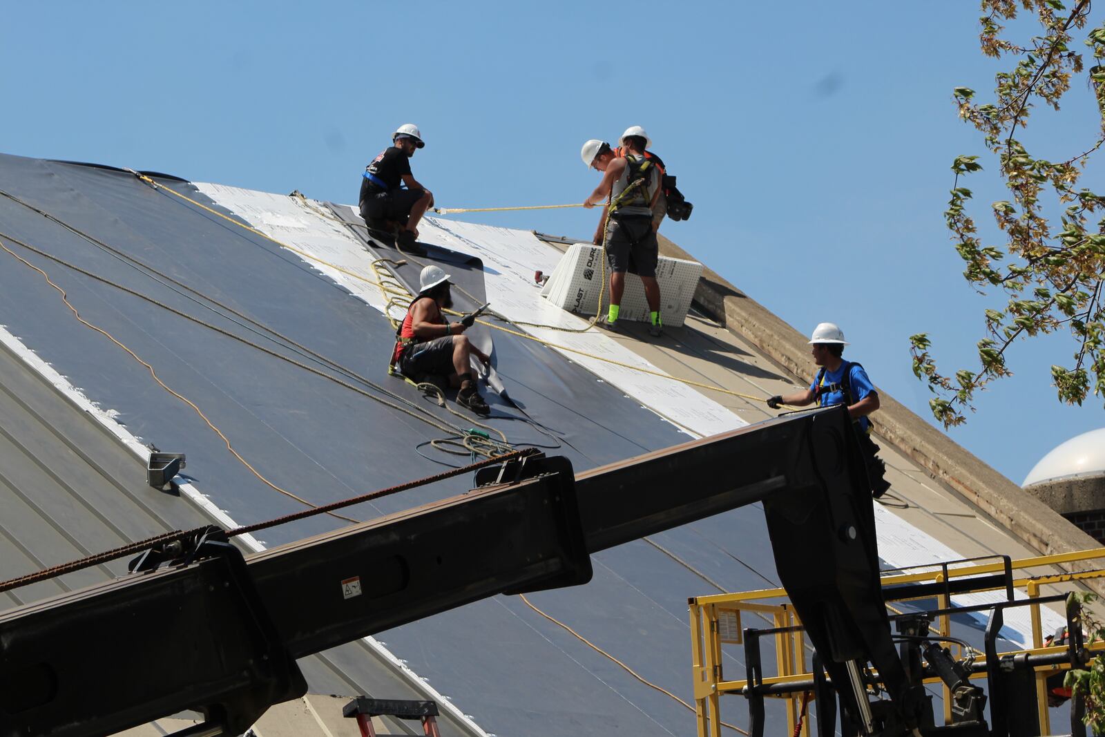 Construction workers work on a roof of a downtown Dayton building. CORNELIUS FROLIK / STAFF