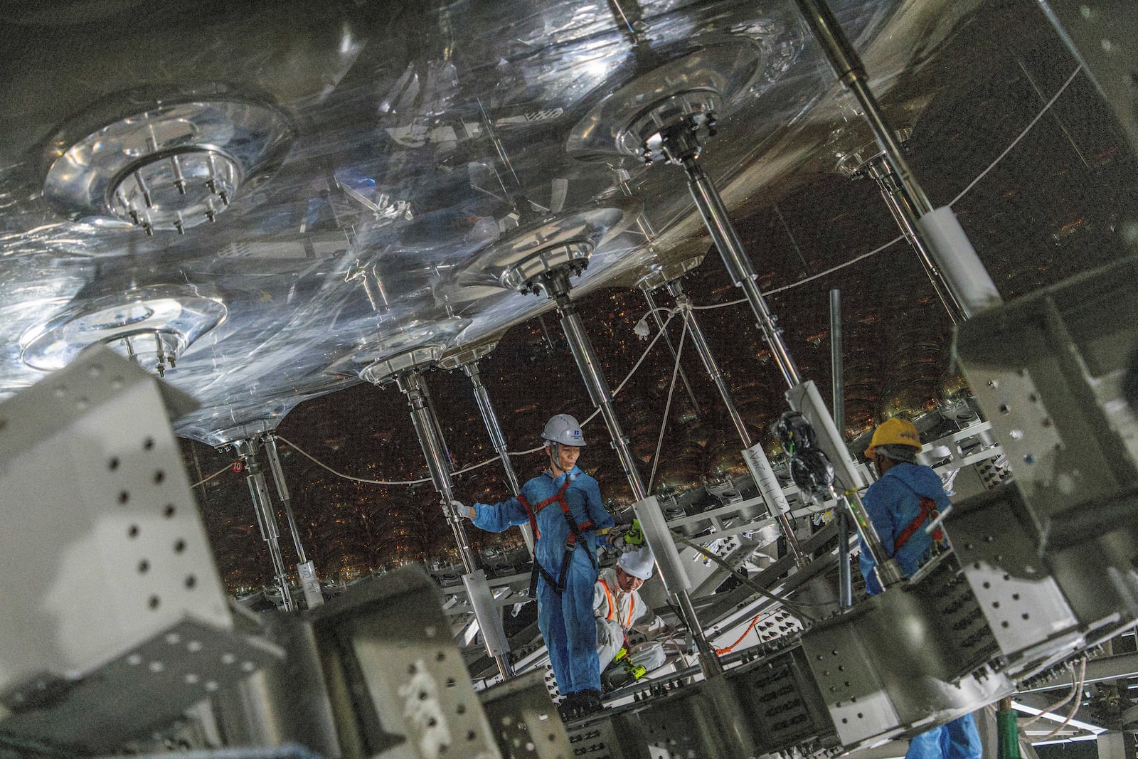 Workers labor on the underside of the cosmic detector located 2297 feet (700 meters) underground at the Jiangmen Underground Neutrino Observatory in Kaiping, southern China's Guangdong province on Friday, Oct. 11, 2024. (AP Photo/Ng Han Guan)