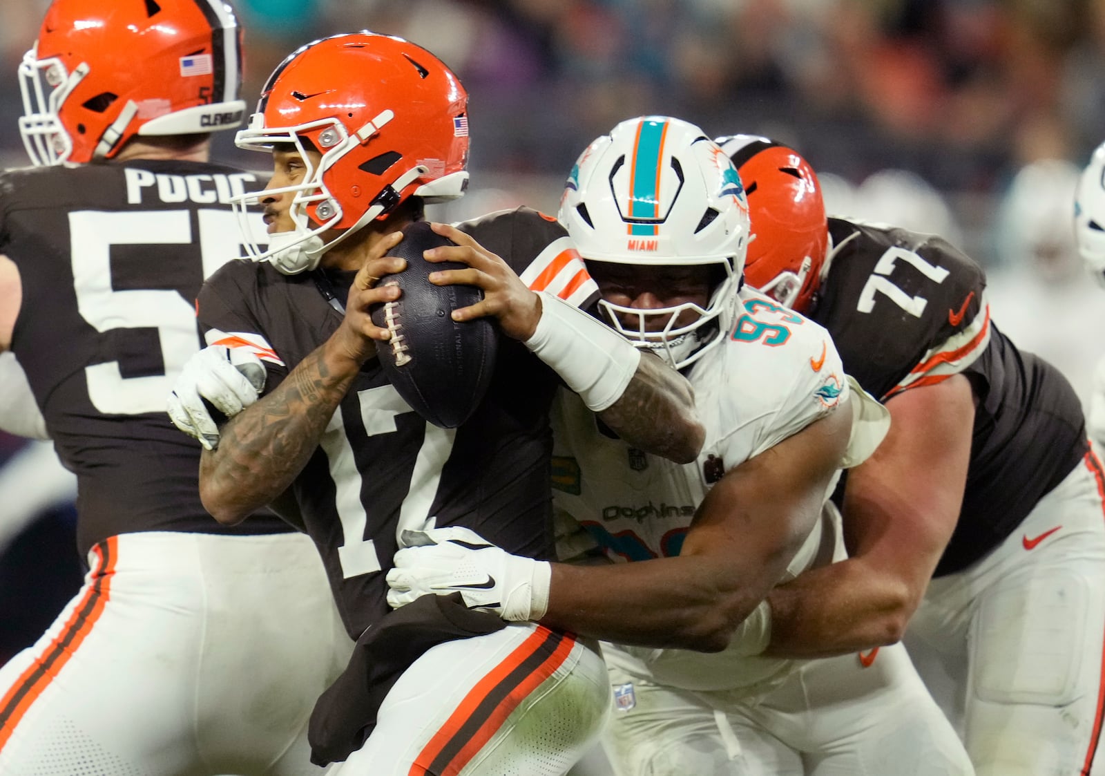 Cleveland Browns quarterback Dorian Thompson-Robinson (17) is pressured by Miami Dolphins defensive tackle Calais Campbell (93) during the second half of an NFL football game Sunday, Dec. 29, 2024, in Cleveland. (AP Photo/Sue Ogrocki)