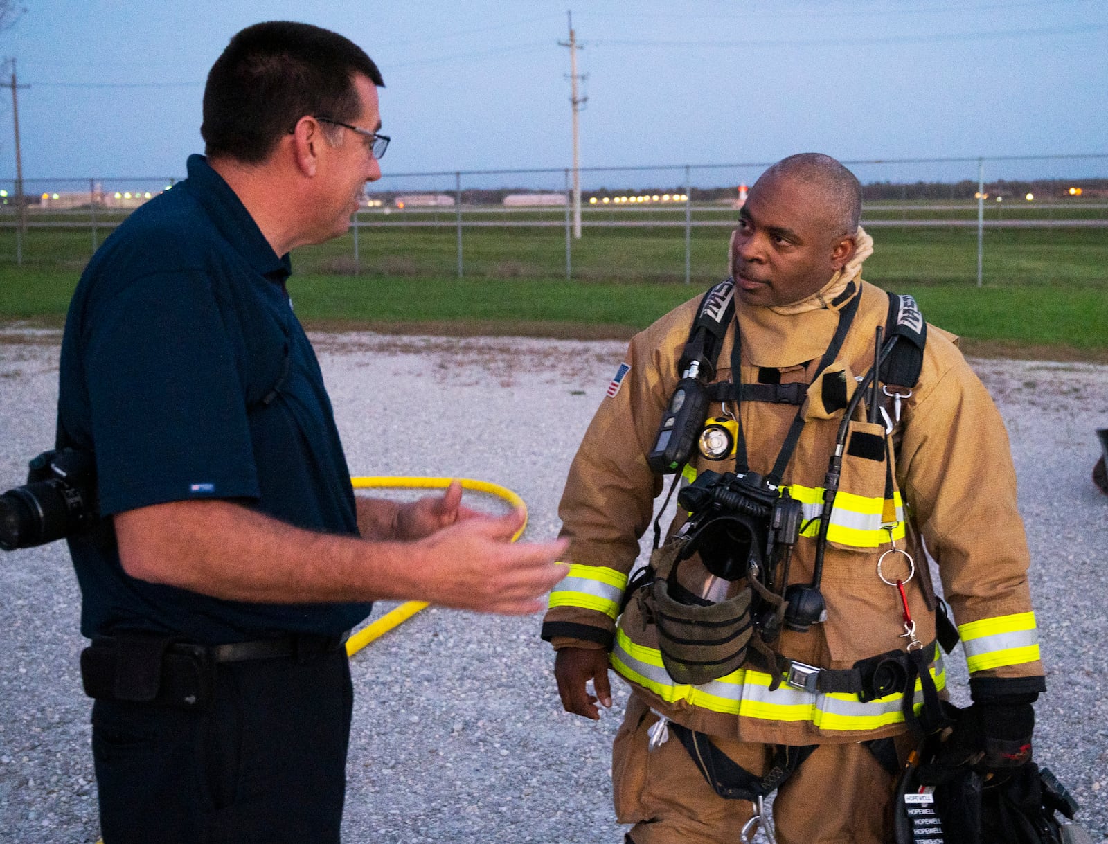 Chief Duane Stitzel (left), Dayton International Airport Fire Department, talks with Jerry Hopewell, 788th Civil Engineer Squadron Fire Department firefighter and emergency medical technician, on Oct. 5 after one of his crews extinguished a live training fire at Wright-Patterson Air Force Base. Hopewell was among the Wright-Patt firefighters who monitored and advised DIA counterparts. (U.S. Air Force photo by R.J. Oriez)