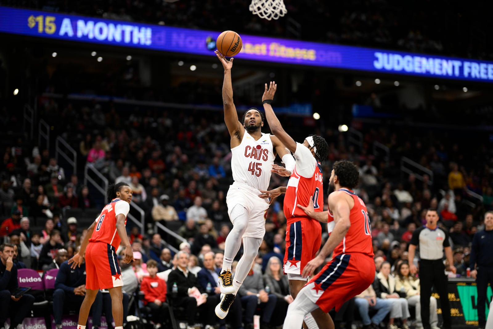 Cleveland Cavaliers guard Donovan Mitchell (45) goes to the basket against Washington Wizards guard Bilal Coulibaly (0), guard Bub Carrington (8) and forward Anthony Gill, front right, during the first half of an NBA basketball game, Friday, Feb. 7, 2025, in Washington. (AP Photo/Nick Wass)