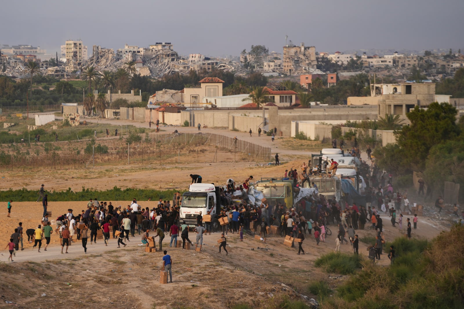 FILE - Palestinians are storming trucks loaded with humanitarian aid brought in through a new U.S.-built pier, in the central Gaza Strip, on May 18, 2024. (AP Photo/Abdel Kareem Hana, File)