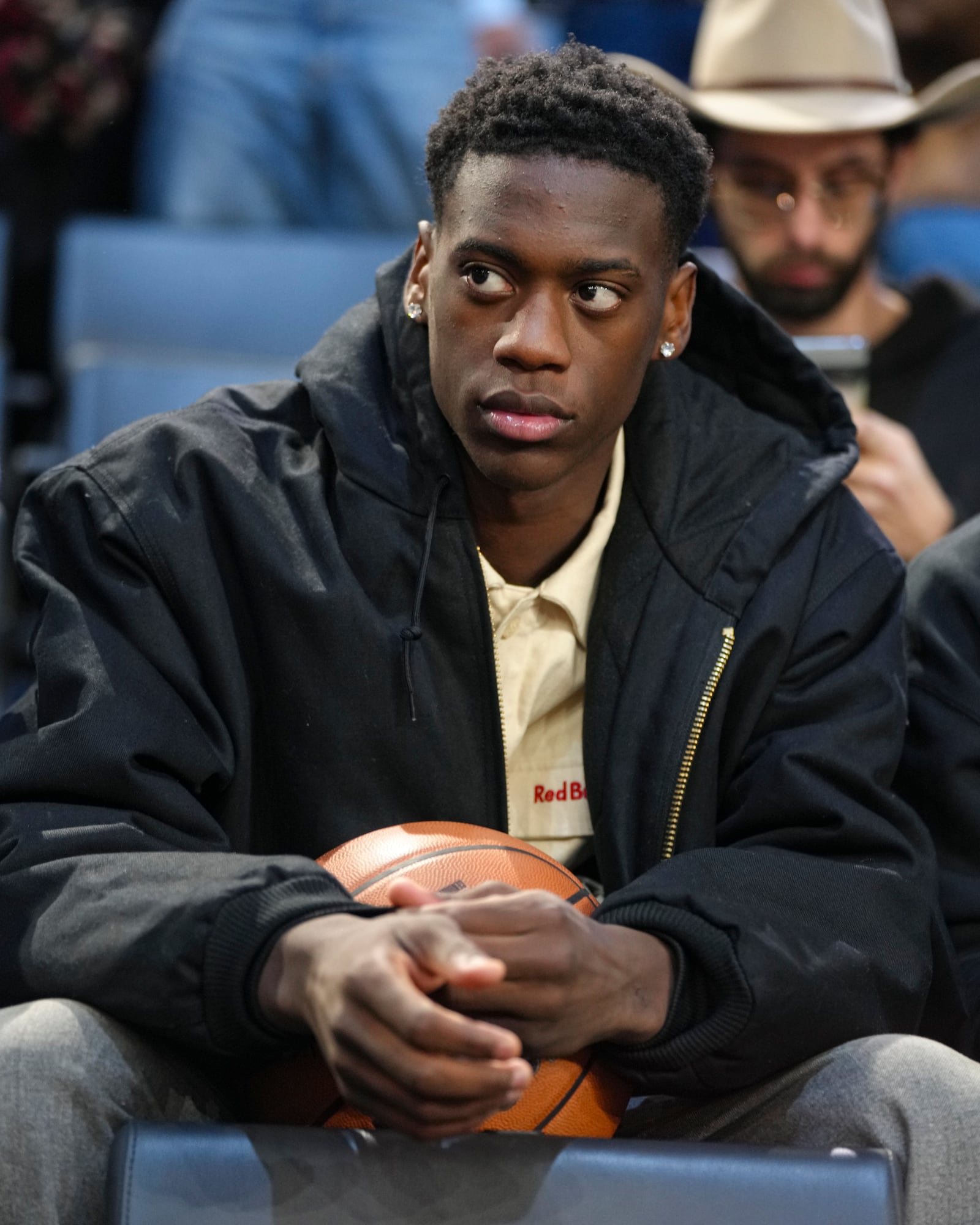 AJ Dybantsa, a BYU commit and projected 2026 NBA draft pick sits in the stand before a Paris Games 2025 NBA basketball game between the Indiana Pacers and the San Antonio Spurs in Paris, Saturday, Jan. 25, 2025. (AP Photo/Thibault Camus)