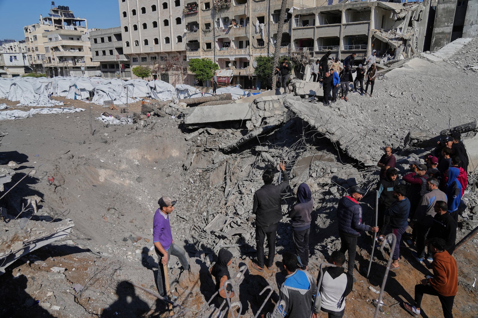 Palestinians inspect the site hit by an Israeli bombardment, in Gaza City on Sunday, March 23, 2025. (AP Photo/Jehad Alshrafi)