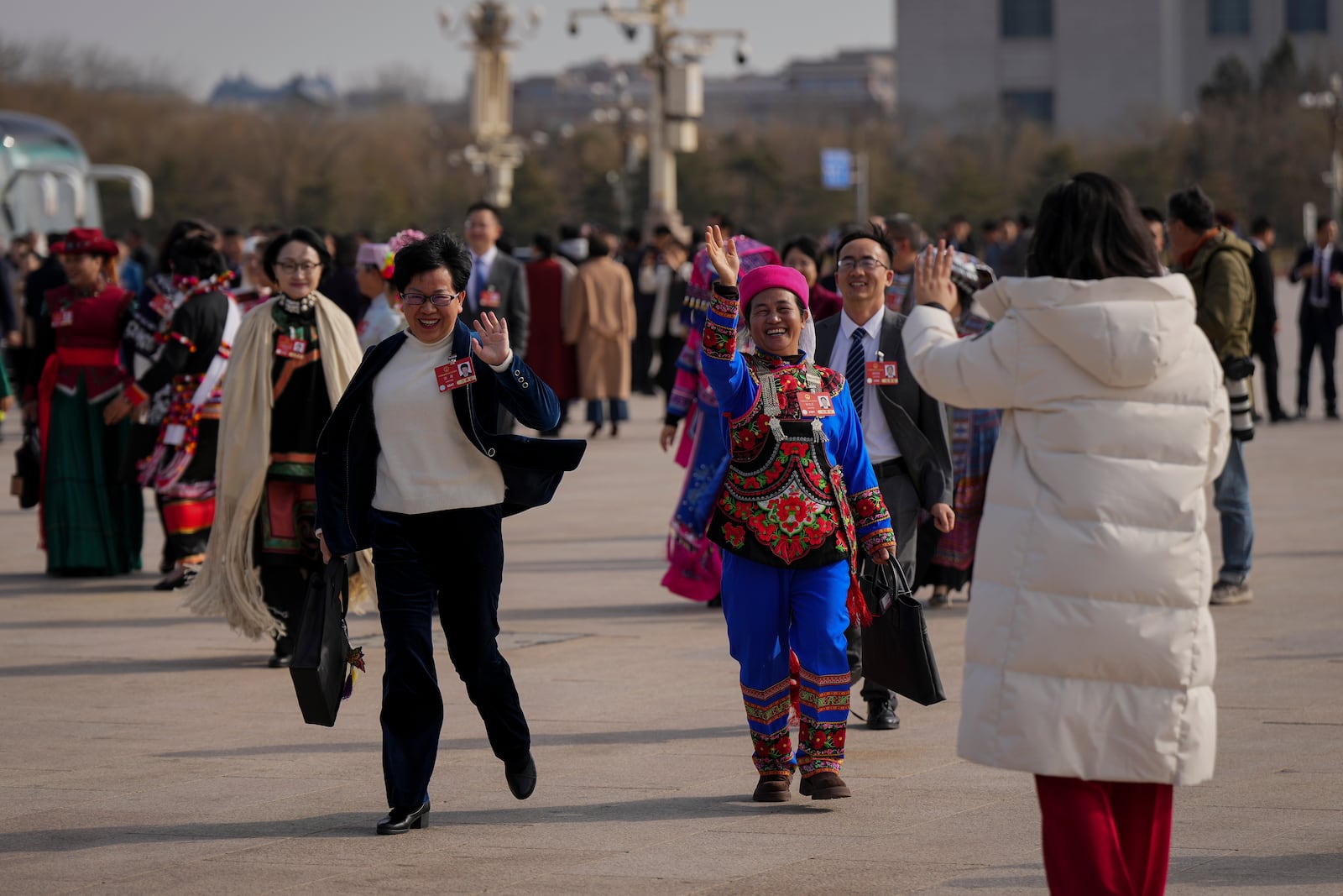 Delegates wave as they arrive to Tiananmen Square to attend a preparatory session of the National People's Congress at the Great Hall of the People in Beijing, Tuesday, March 4, 2025. (AP Photo/Andy Wong)