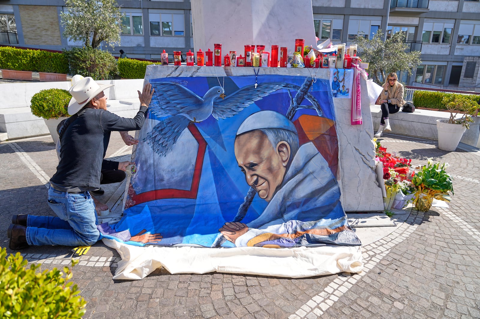 Mexican painter Roberto Marquez places a painting of Pope Francis he made outside the Agostino Gemelli hospital in Rome, Wednesday, March 5, 2025. (AP Photo/Gregorio Borgia)