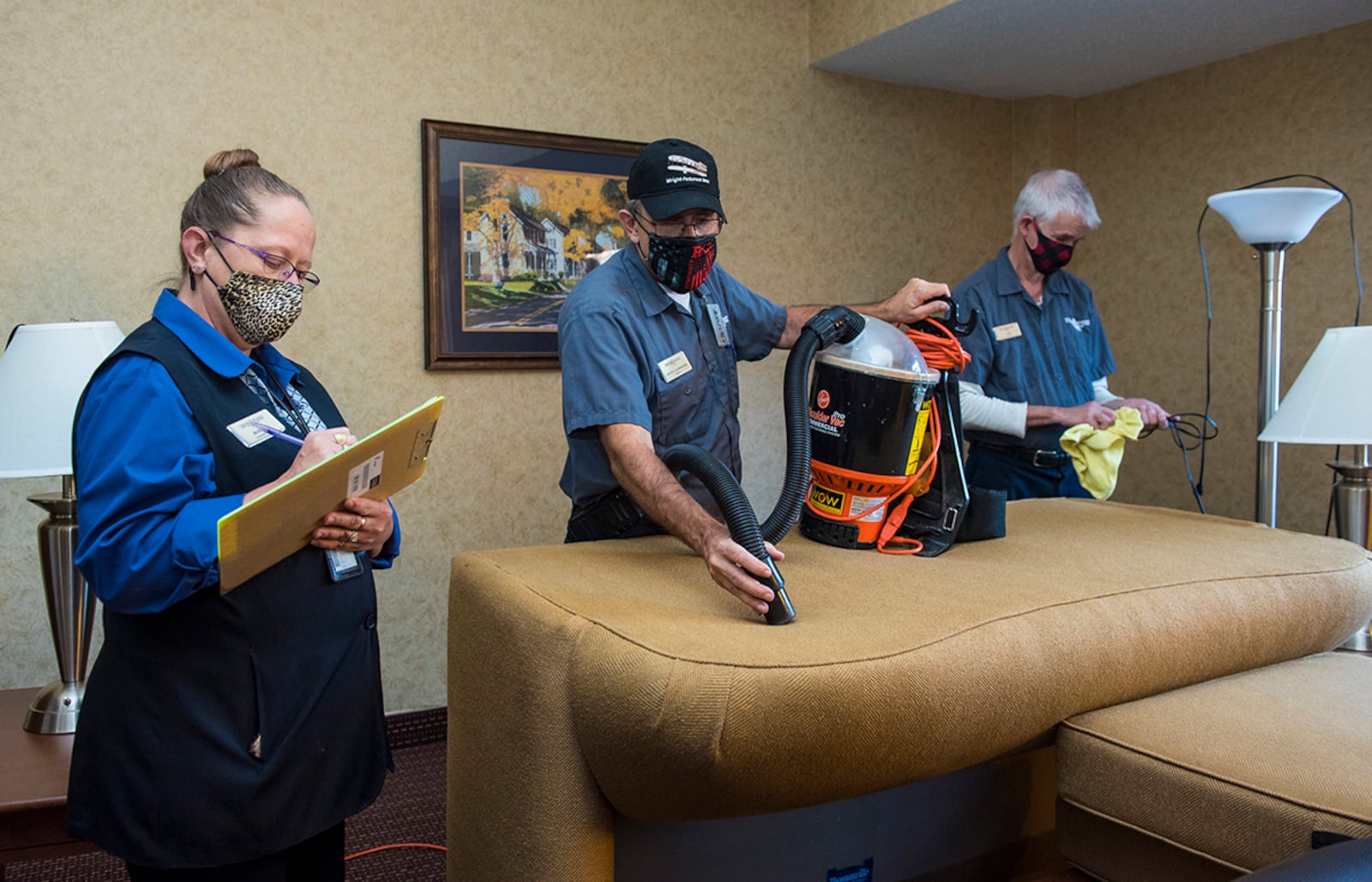 Sheila Reiser (left), Wright-Patterson Inn operations manager, inspects the work of laborers Kevin Owens (center) and Tim Foley as they deep clean a guestroom. U.S. AIR FORCE PHOTO/JAIMA FOGG