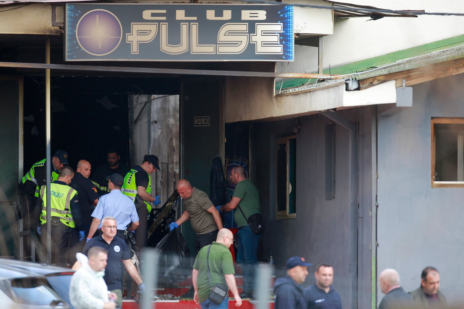 Police officers hold plastic bags on the site of a nightclub in the town of Kocani, North Macedonia, Sunday, March 16, 2025, following a massive fire in the nightclub early Sunday. (AP Photo/Visar Kryeziu)