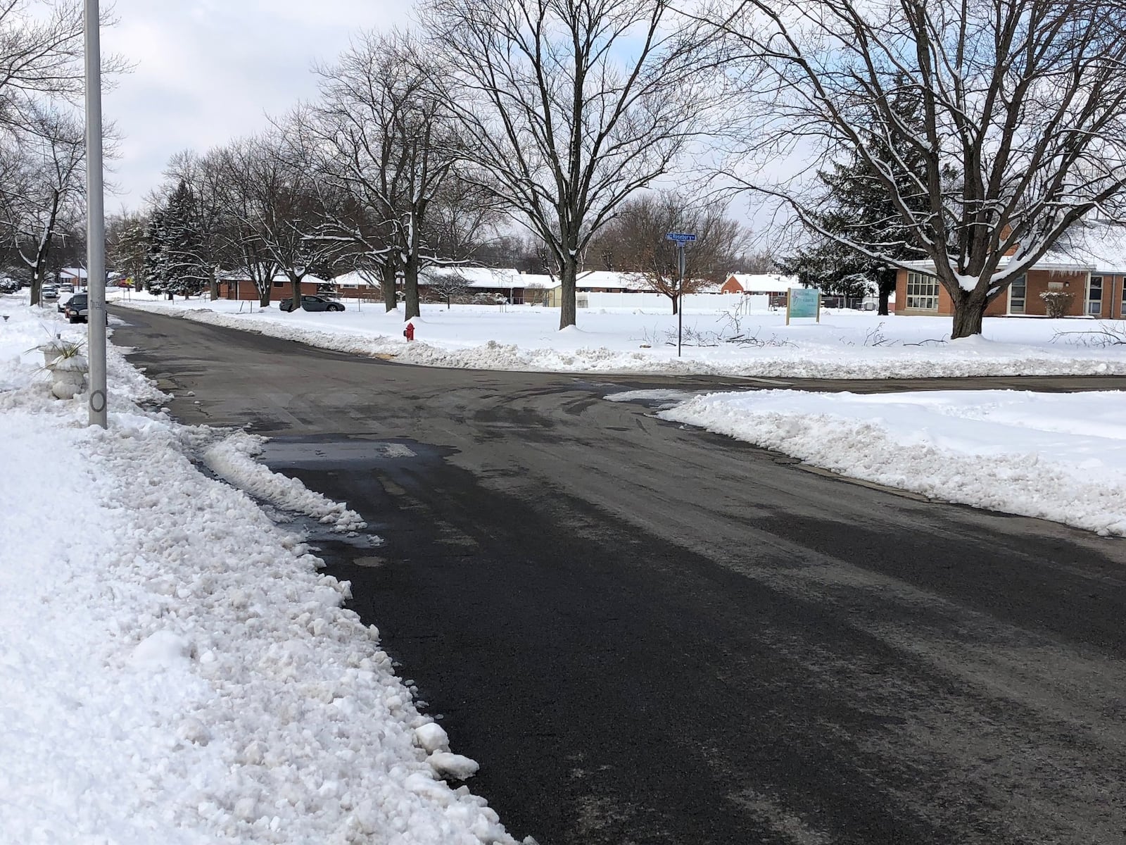 Snow has been cleared from pavement at the corner of Rosebury Drive and Rittenhouse Drive in Huber Heights, on Monday, Jan. 14, 2019.