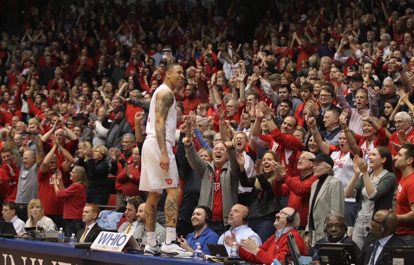 Dayton’s Kyle Davis celebrates on the press row table after the Flyers beat Virginia Commonwealth for their first outright Atlantic 10 title Wednesday at UD Arena. DAVID JABLONSKI / STAFF