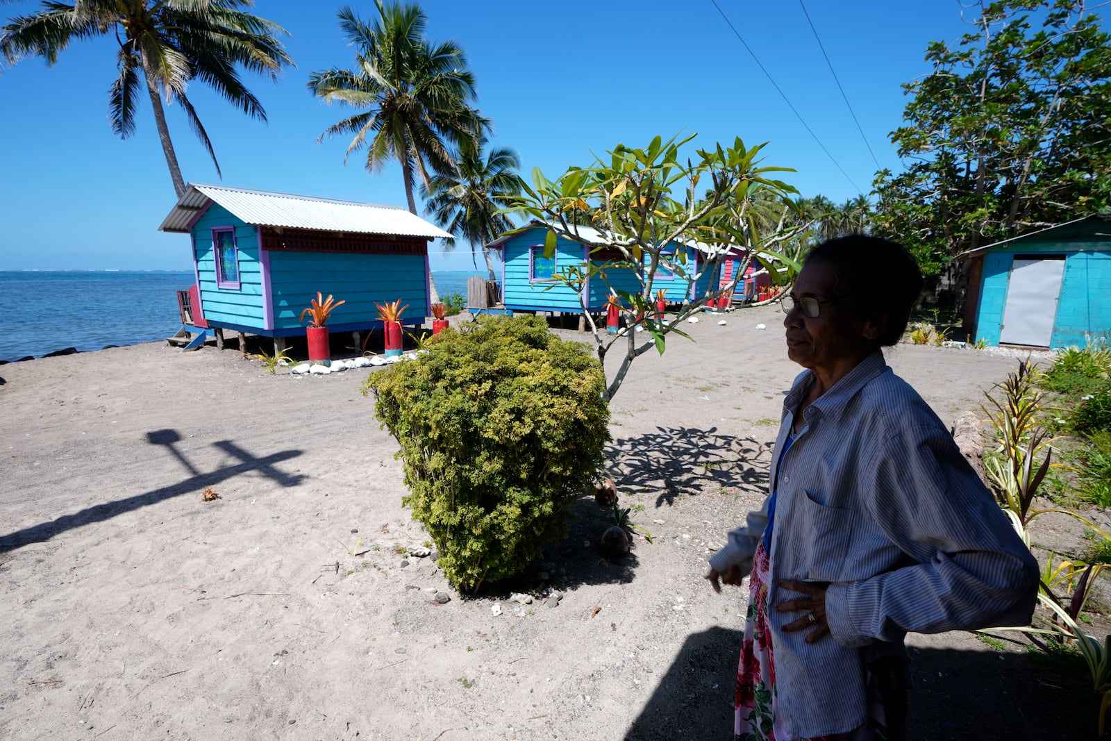 Netina Malae stands in the shade at her Sima PJ Beach Fale resort in the village of Tafitoala, Samoa, on Monday, Oct. 21, 2024, near where a New Zealand navy ship ran aground and sank on Oct. 6. (AP Photo/Rick Rycroft)