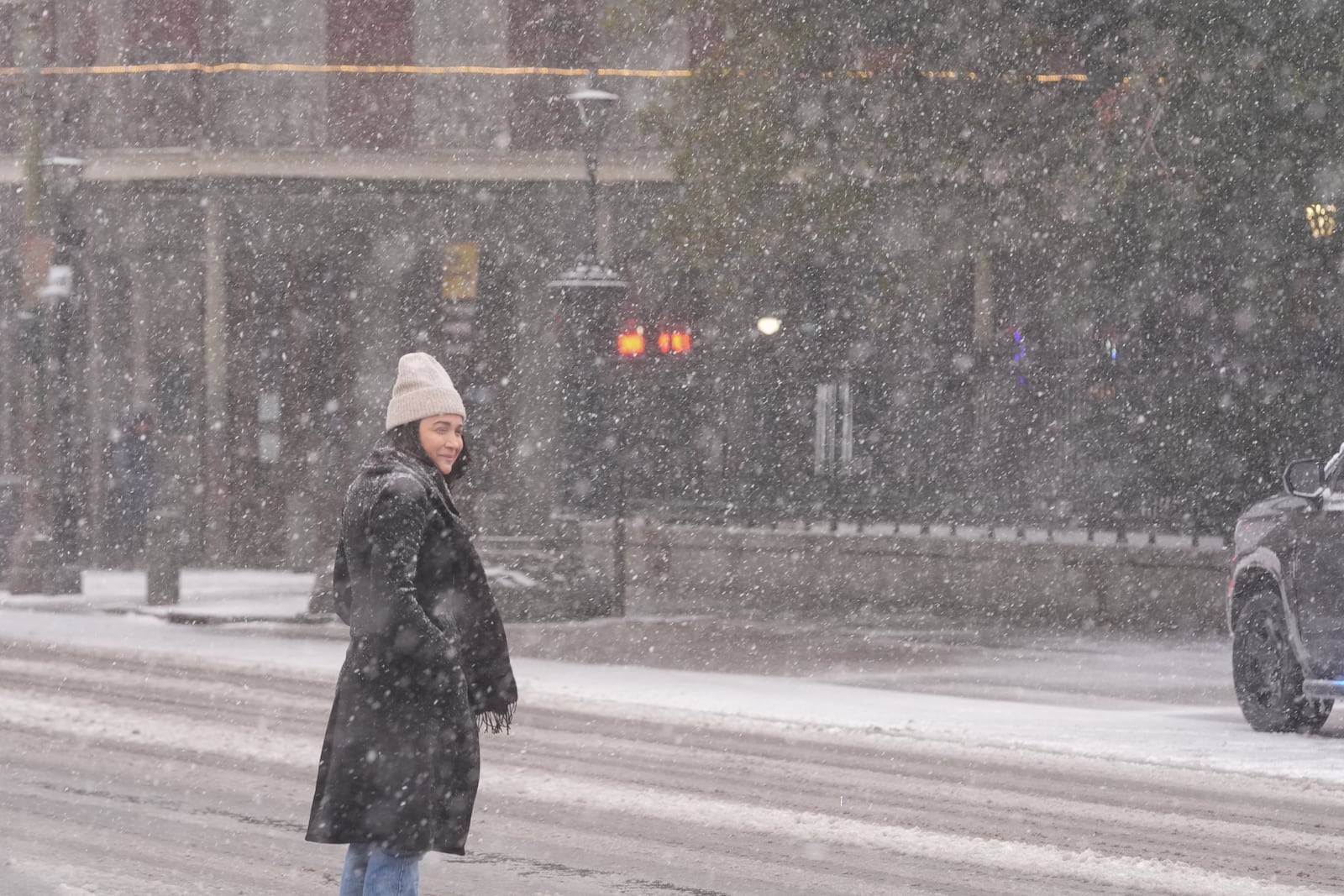 A person walks to Jackson Square as snow falls in the French Quarter in New Orleans, Tuesday, Jan. 21, 2025. (AP Photo/Gerald Herbert)