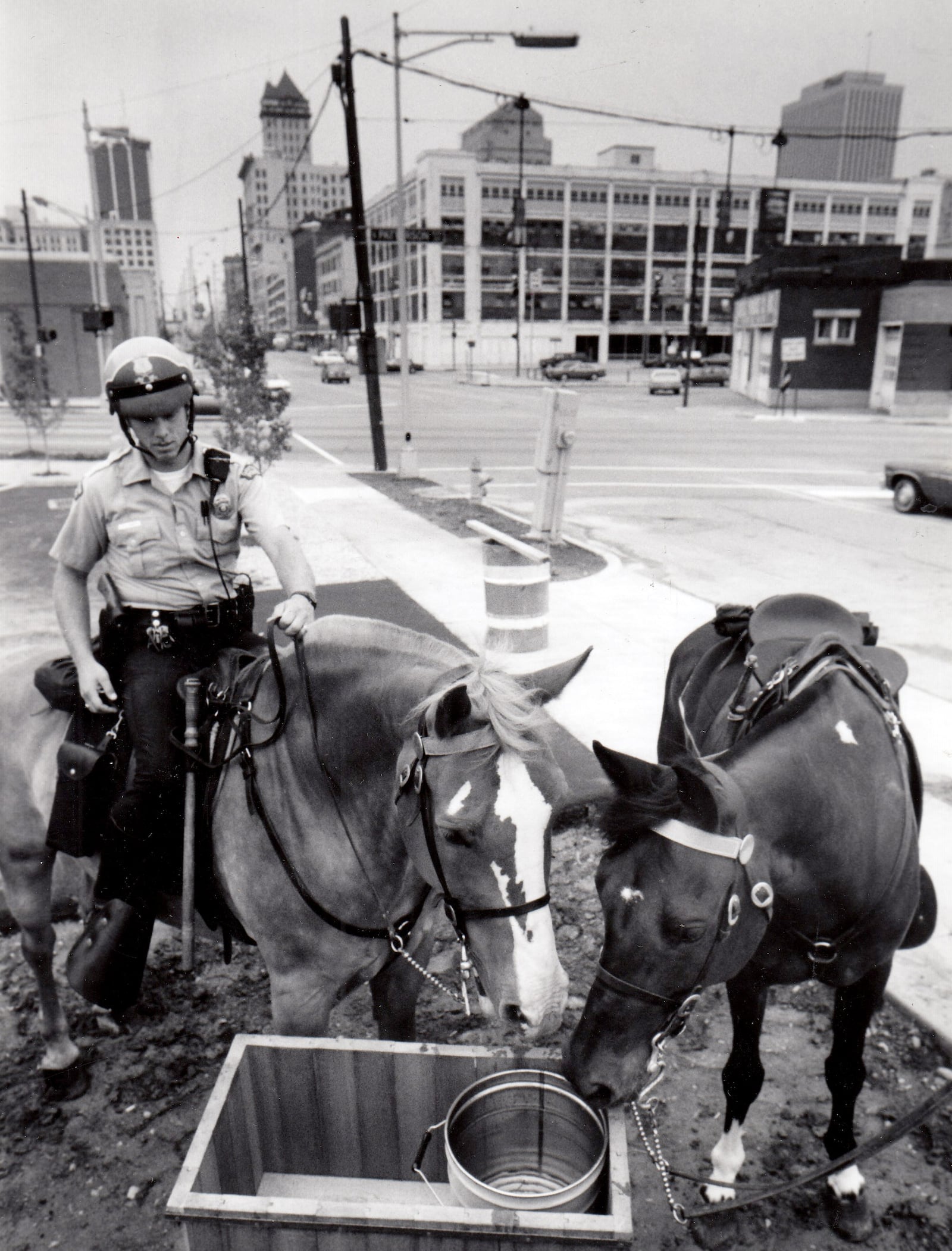 Police officer Tim Zimmer and his horse "Peanut" inspect a new downtown Dayton watering hole in 1989 near Fourth Street and Patterson Boulevard, courtesy of Hauer Music. The other horse, "Spanky" belongs to Officer Steve Holland.  DAYTON DAILY NEWS ARCHIVE