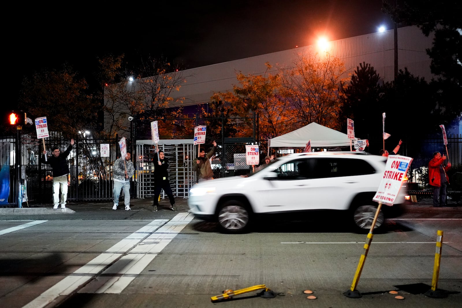 Boeing employees cheer and wave picket signs as a driver honks in support after a majority of union members voted to reject a new contract offer from the company, Wednesday, Oct. 23, 2024, in Renton, Wash. (AP Photo/Lindsey Wasson)