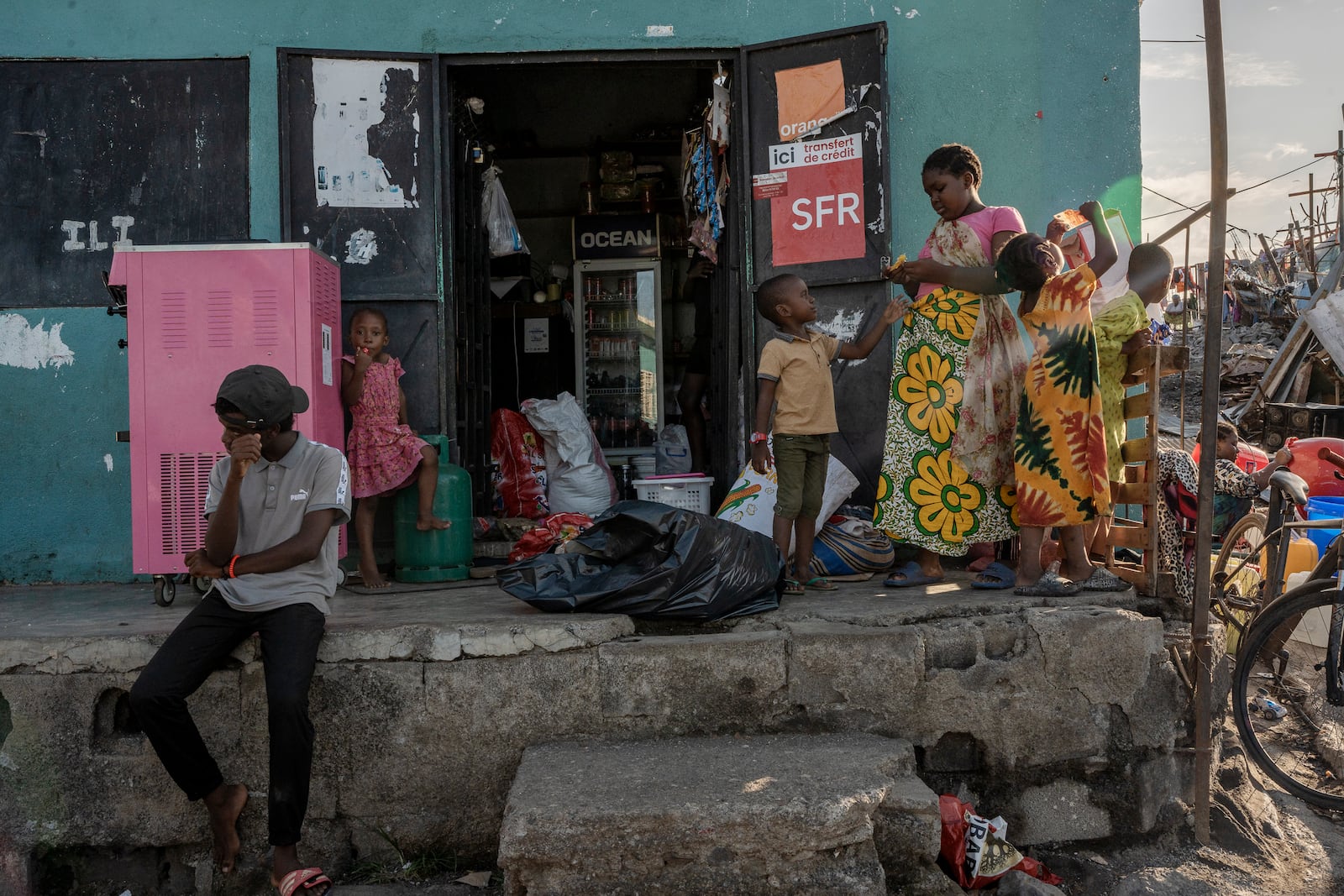 Children play in a small shop in Majicavo Koropa, Mayotte, Friday, Dec. 20, 2024. (AP Photo/Adrienne Surprenant)