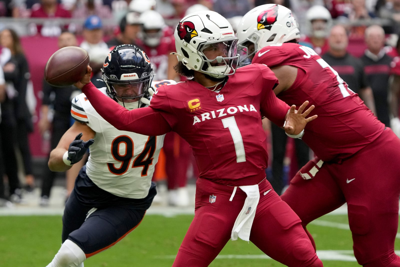 Arizona Cardinals quarterback Kyler Murray (1) throws under pressure from Chicago Bears defensive end Austin Booker (94) during the first half of an NFL football game, Sunday, Nov. 3, 2024, in Glendale, Ariz. (AP Photo/Rick Scuteri)