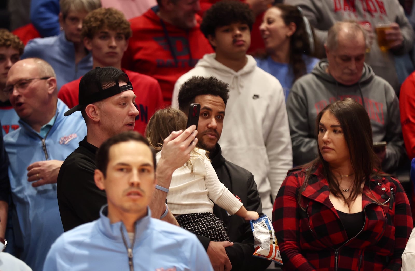 Former Flyer Brian Roberts, center, watches Dayton's game against Marquette on Saturday, Dec. 14, 2024, at UD Arena. David Jablonski/Staff