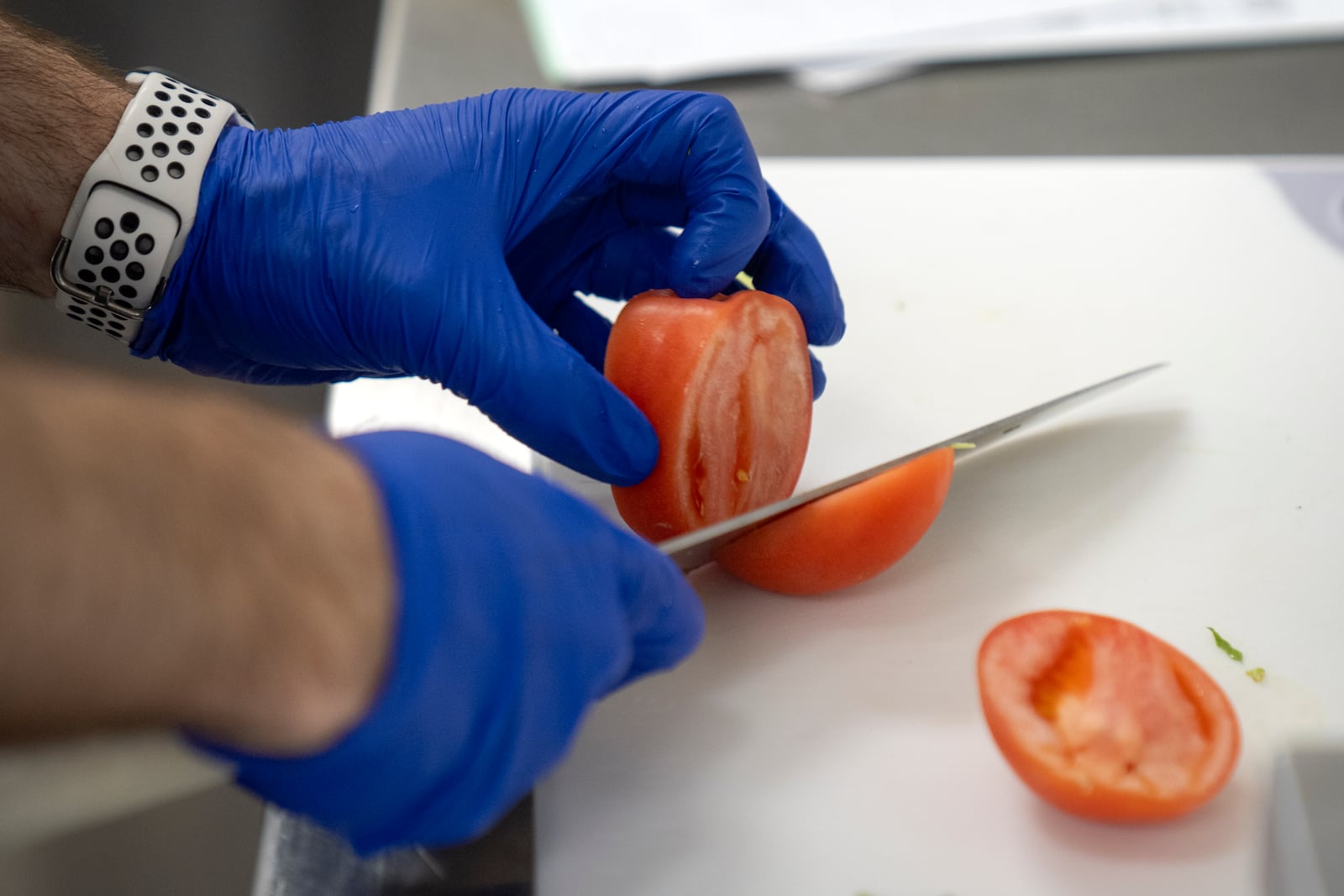 Cook Jeff Tait slices a tomato as he prepares a meal for college student and research subject Sam Srisatta in a kitchen during a study on the health effects of ultraprocessed foods at the National Institutes of Health in Bethesda, Md., on Thursday, Oct. 31, 2024. (AP Photo/Mark Schiefelbein)