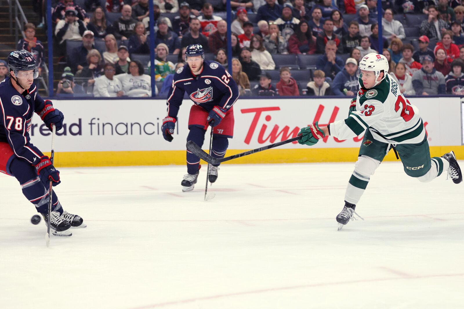 Minnesota Wild forward Marco Rossi, right, shoots the puck in front of Columbus Blue Jackets defenseman Damon Severson, left, and forward Mathieu Olivier during the first period of an NHL hockey game in Columbus, Ohio, Saturday, Oct. 19, 2024. Rossi scored on the play. (AP Photo/Paul Vernon)