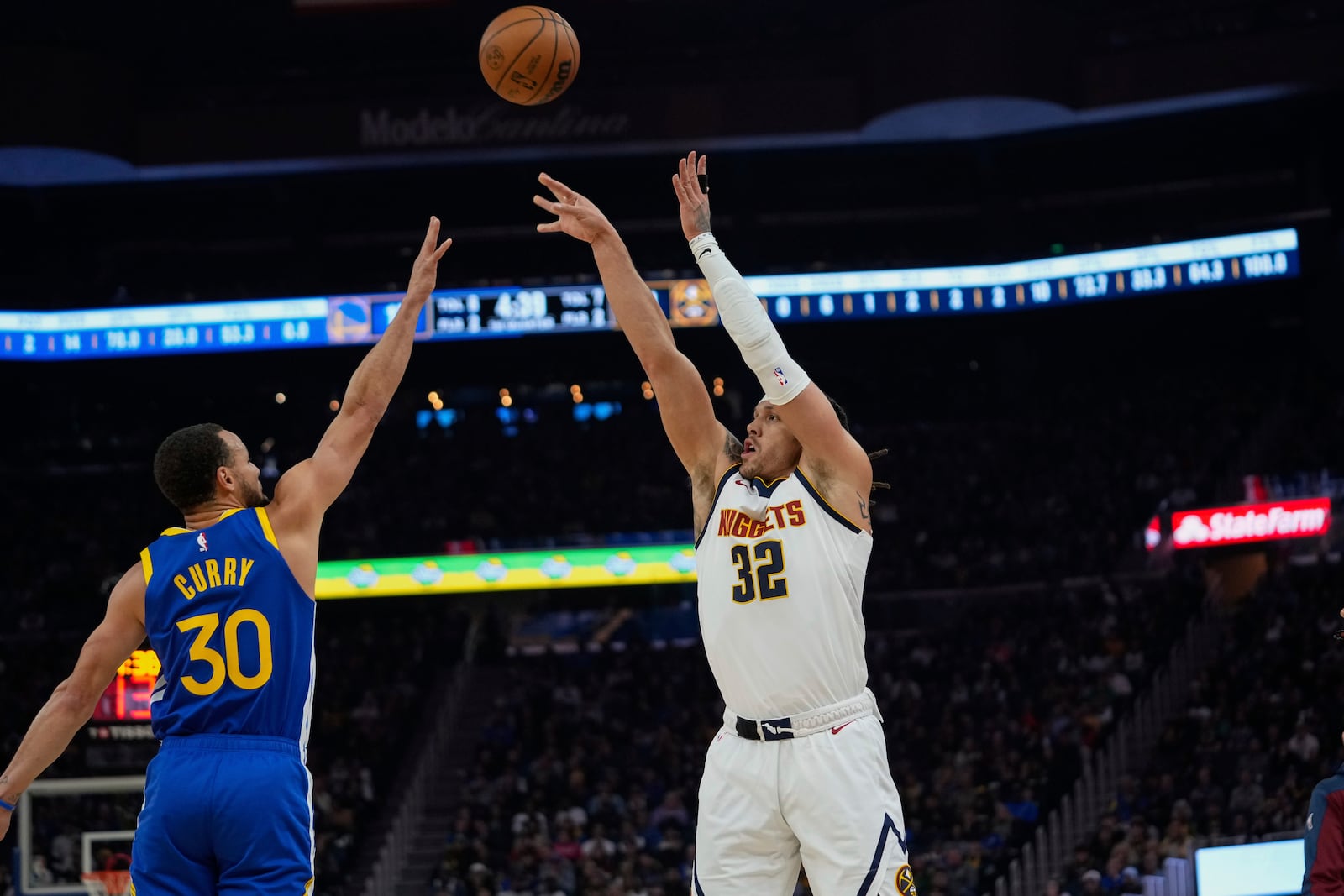 Denver Nuggets forward Aaron Gordon, right shoots a 3-point basket over Golden State Warriors guard Stephen Curry during the first half of an NBA basketball game Monday, March 17, 2025, in San Francisco. (AP Photo/Godofredo A. Vásquez)