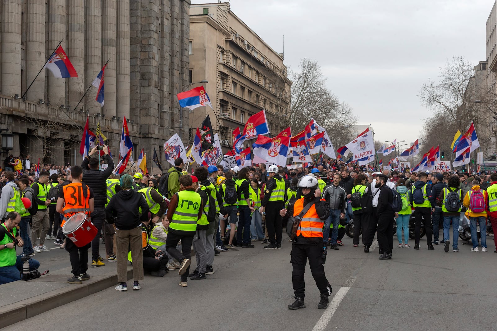 Protesters block a street while waving Serbian flags during a major anti-corruption rally led by university students in Belgrade, Serbia, Saturday, March 15, 2025. (AP Photo/Marko Drobnjakovic)