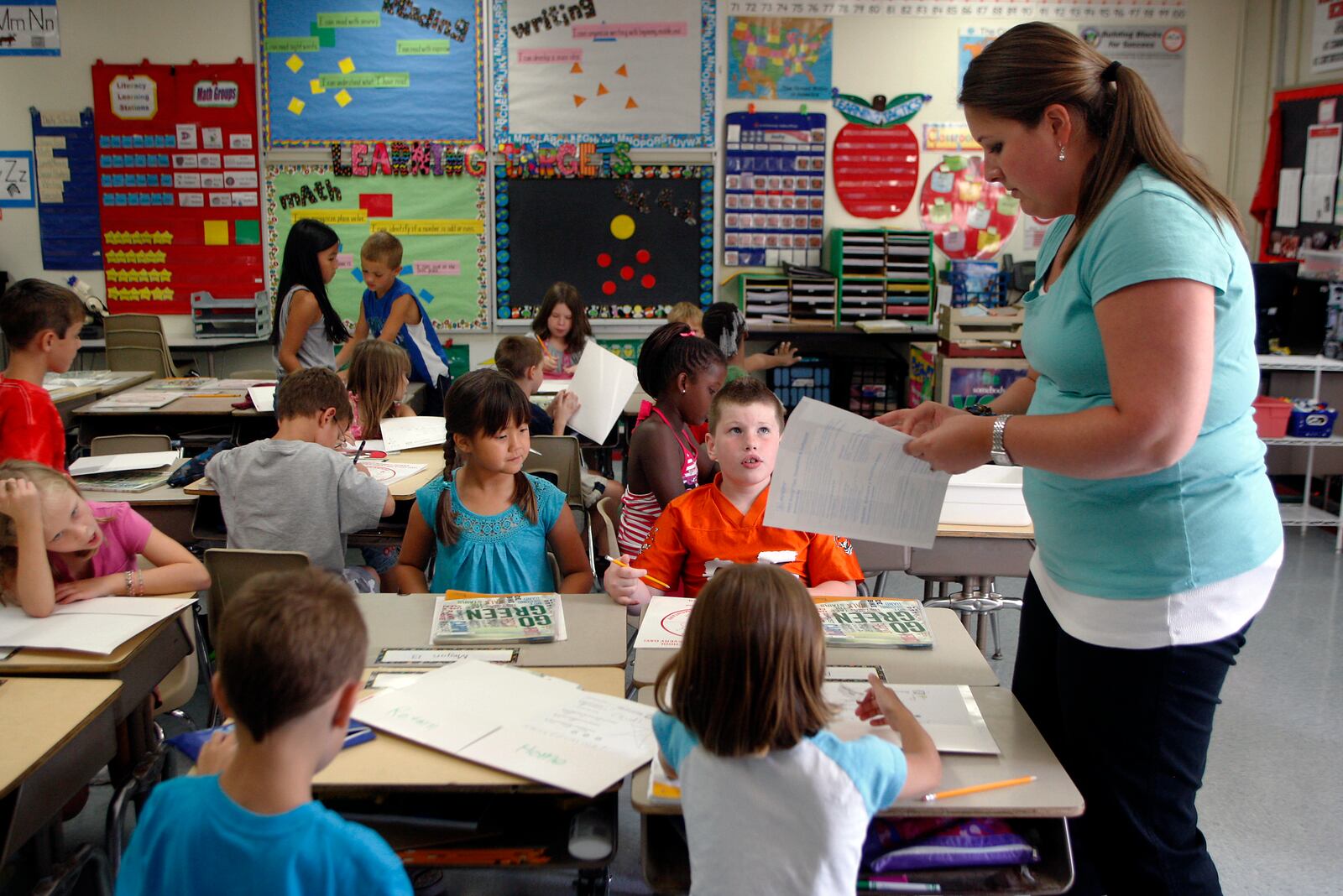 Teacher Ashley Cable passes out stickers to students in her second grade class on Wednesday, July 13, the second day of school at Harold Schnell Elementary in West Carrollton.