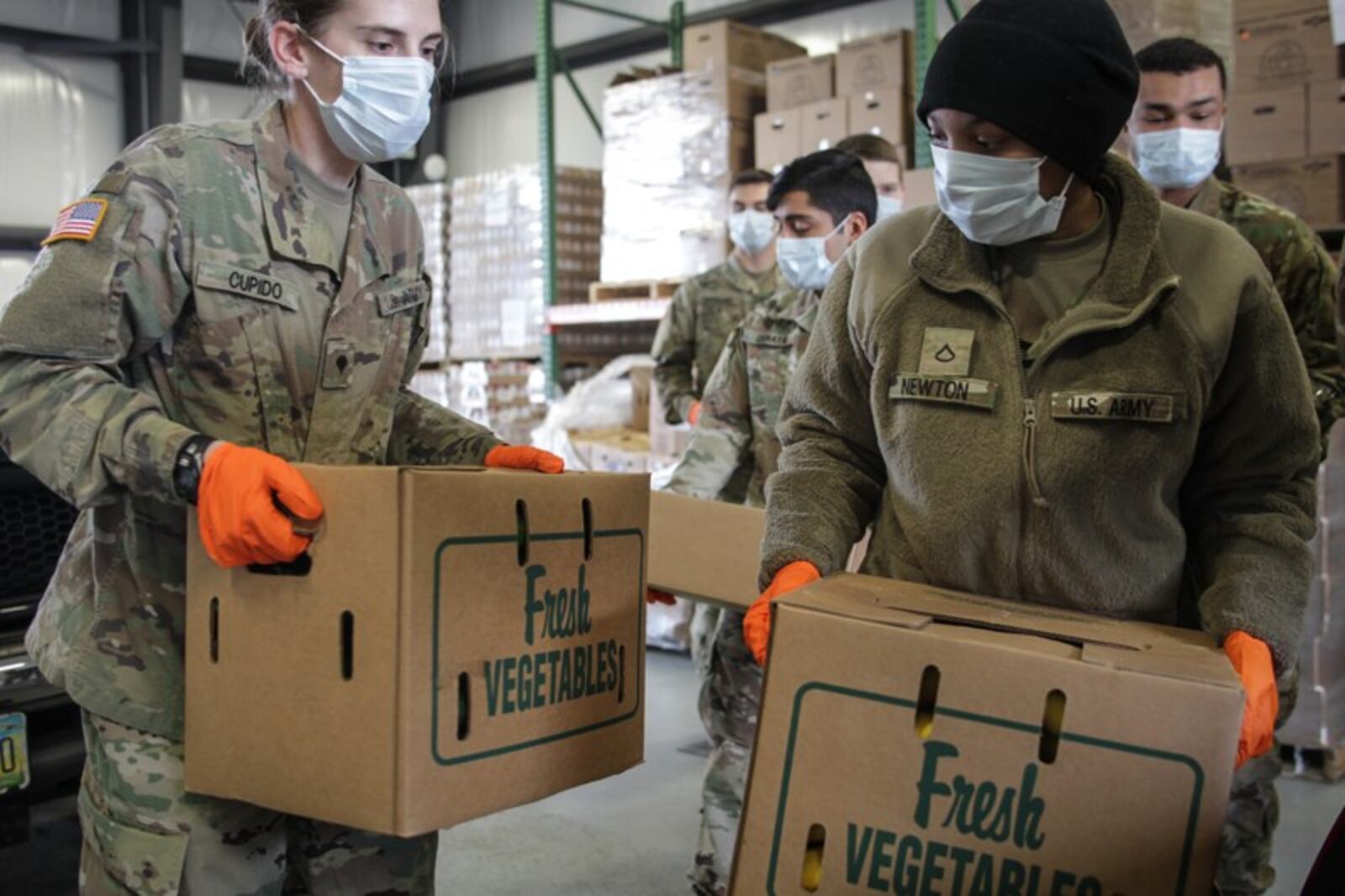 Ohio National Guard members help load food into trunks at The Foodbank at 56 Armor Place in Dayton. STAFF/JIM NOELKER