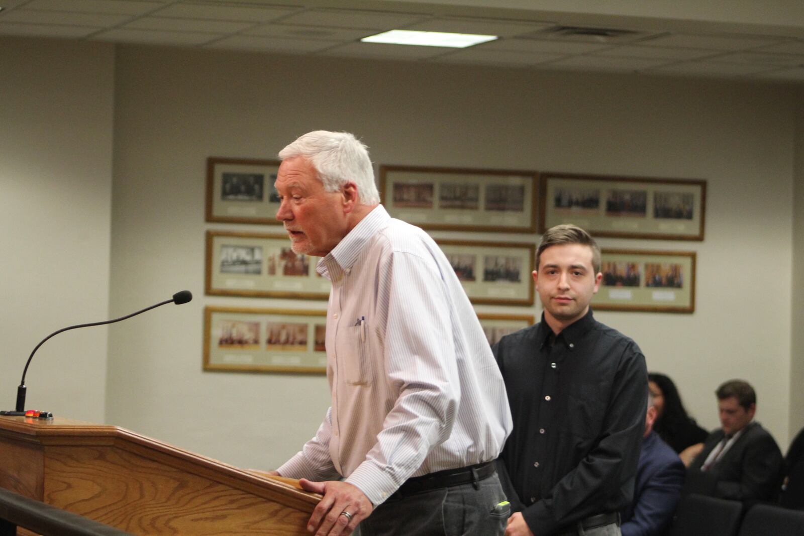 Butch Brown (speaking to Dayton City Commission) and Zach Curry (right) will launch a new podcast focused on unsolved homicide and sexual assault cases in Dayton, with a goal of generating tips and leads. They will receive assistance from the Dayton Police Department's Cold Case Unit. CORNELIUS FROLIK / STAFF