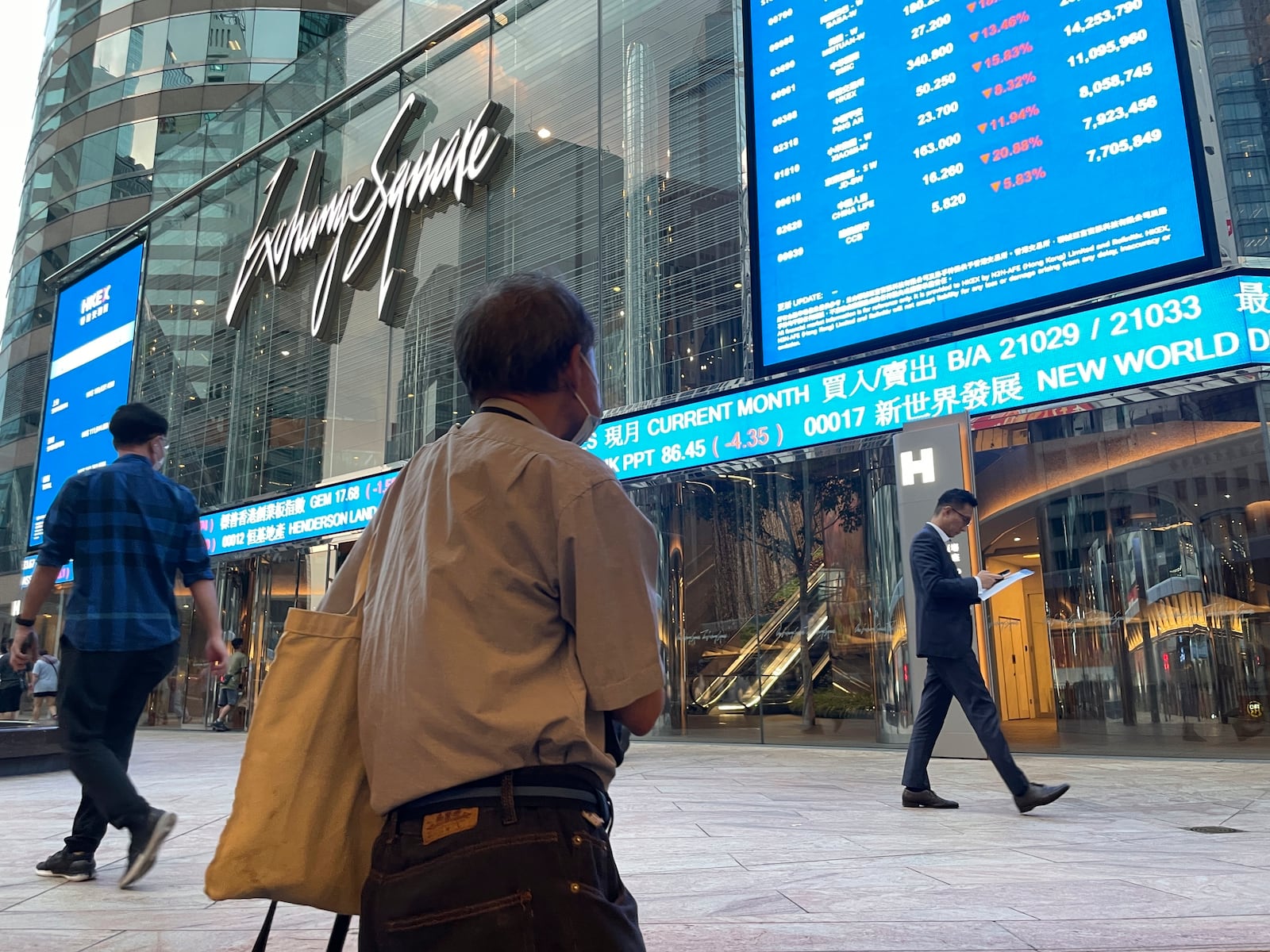 FILE - People walk past Hong Kong's stock exchange building as the market closed with a massive fall of more than nine percent in the benchmark Hang Seng Index, on Oct. 8, 2024. (AP Photo, File)