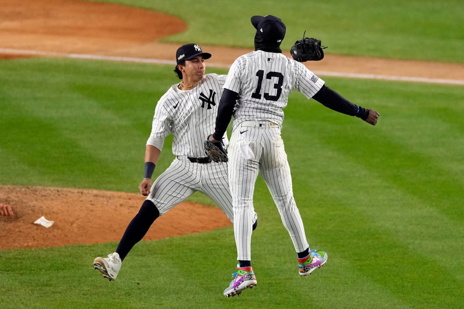 New York Yankees' Jazz Chisholm Jr. (13) and Oswaldo Cabrera celebrate after Game 1 of the baseball AL Championship Series against the Cleveland Guardians Monday, Oct. 14, 2024, in New York. The Yankees won 5-2. (AP Photo/Seth Wenig)