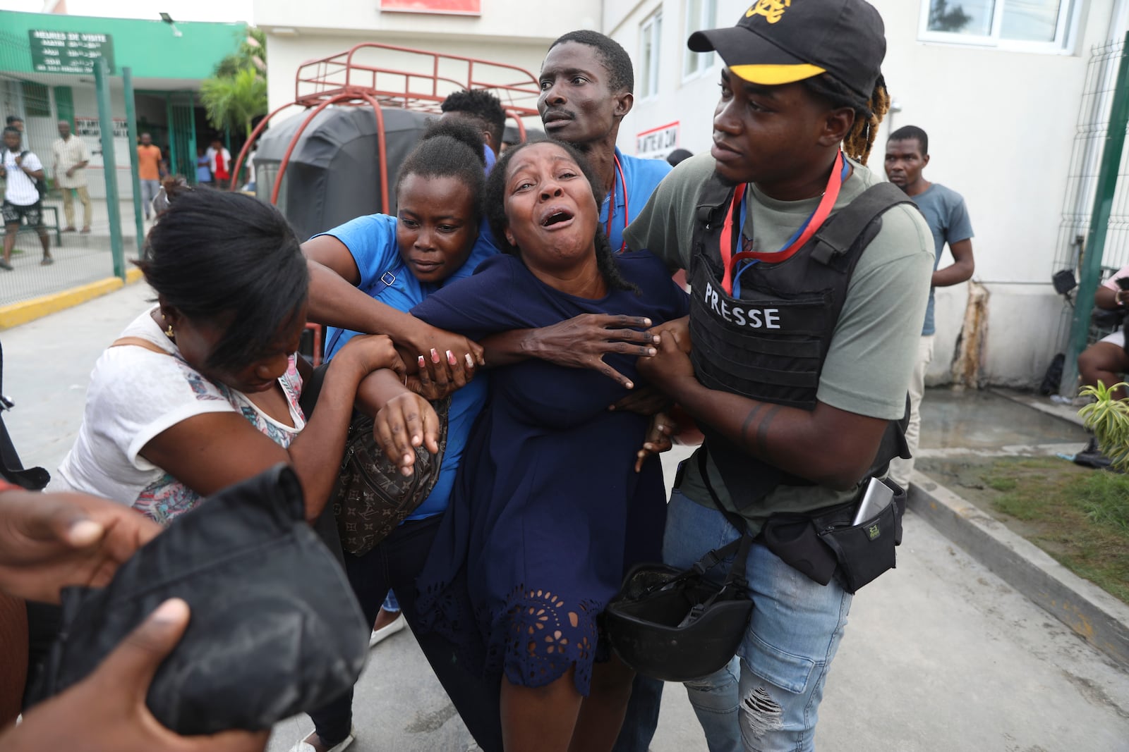 The wife of a journalist, who was shot during an armed gang attack on the General Hospital, cries as an ambulance arrives with his body, at a different hospital in Port-au-Prince, Haiti, Tuesday, Dec. 24, 2024. (AP Photo/Odelyn Joseph)