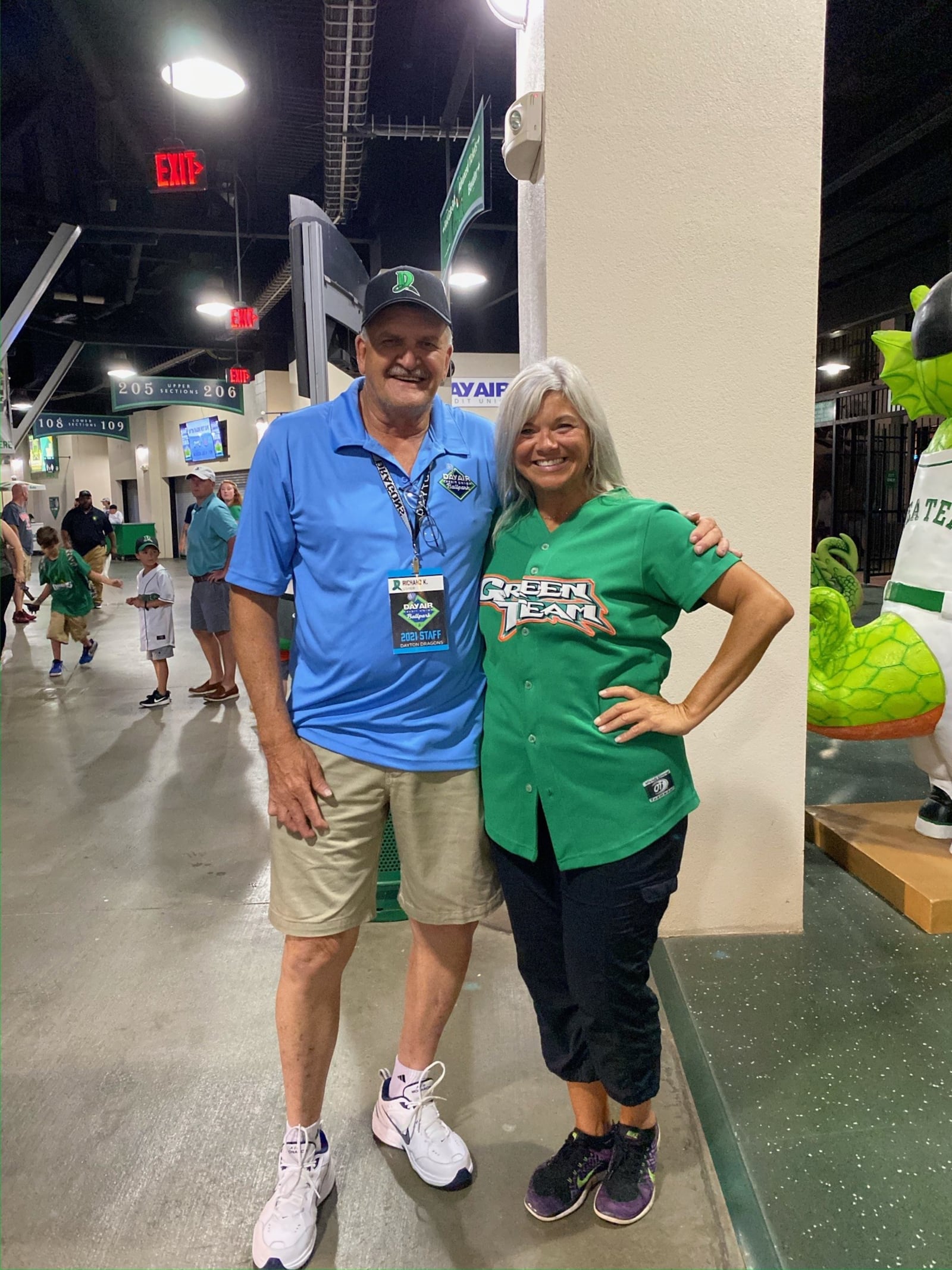 Usher Richard Keehn working a Dayton Dragons game, poses with Madison, one of the Green Team entertainers. CONTRIBUTED