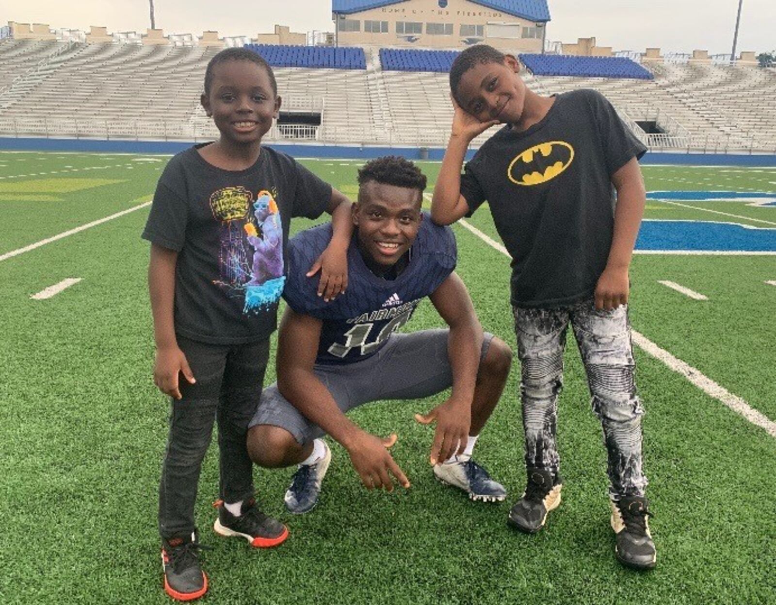 Tolr Kikubi, starting senior linebacker for Fairmont High football team, with his two younger brothers, David (right) and Mechak. Ning Peel/CONTRIBUTED