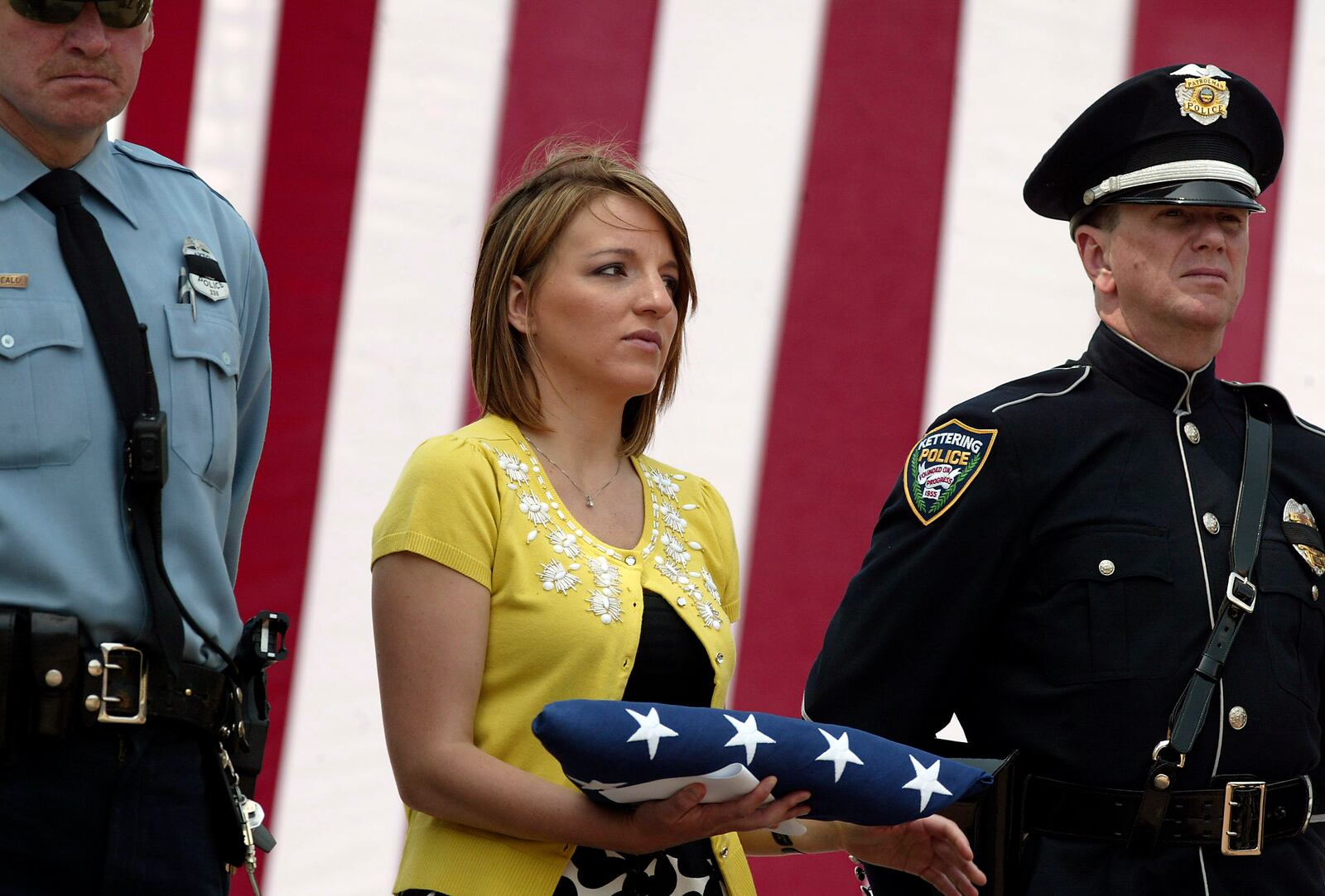 Vanessa Beall holds the flag given to her in honor of her mother fallen Dayton Police Officer Mary Beall during the fourth annual Montgomery County Law Enforecement Memorial Ceremony held Friday, May 7, 2011, in front of Fifth Third Field. Vanessa Beall was guest speaker at the event that honored fallen law enforcement officers throughout the county.