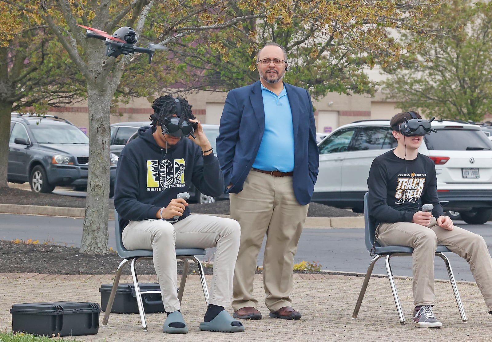 Shadh Molla, professor of Emmanuel Christian Academy Aerospace Institute, watches as Curtis Henry, left, and Tanner Nixon, upper classman at the Academy, fly advanced drones Tuesday, April 23, 2024 outside the school. BILL LACKEY/STAFF