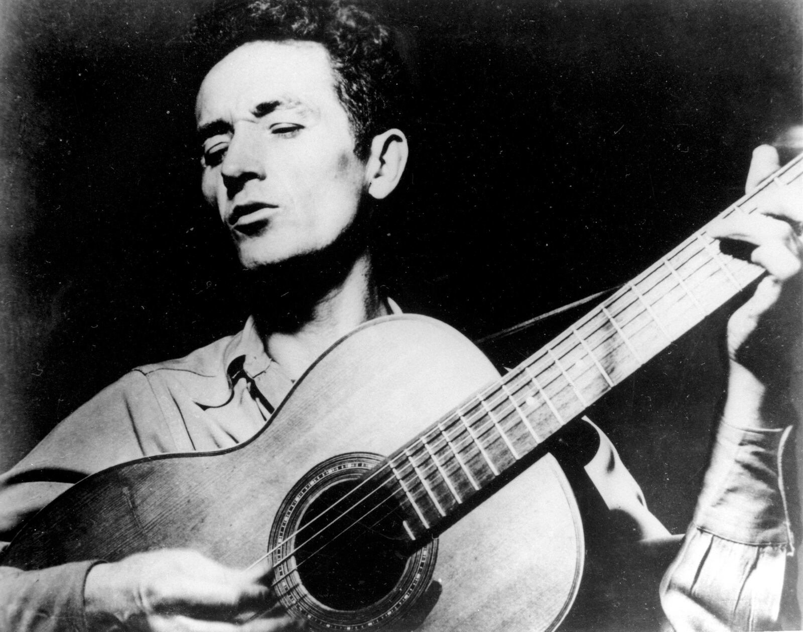 FILE- In this undated photo Oklahoma folk singer Woody Guthrie plays his guitar. (AP Photo, File)