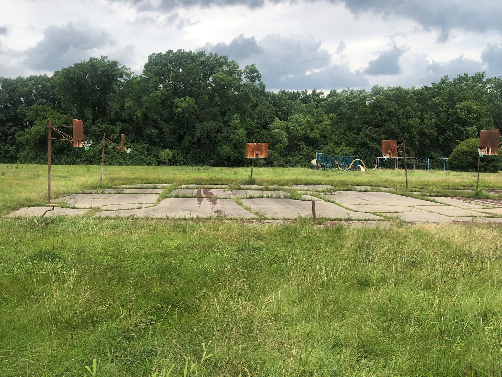 Gettysburg Park in the Westwood neighborhood has knee-high weeds, rusted basketball hoops and trash and tires have been dumped on the property. CORNELIUS FROLIK / STAFF