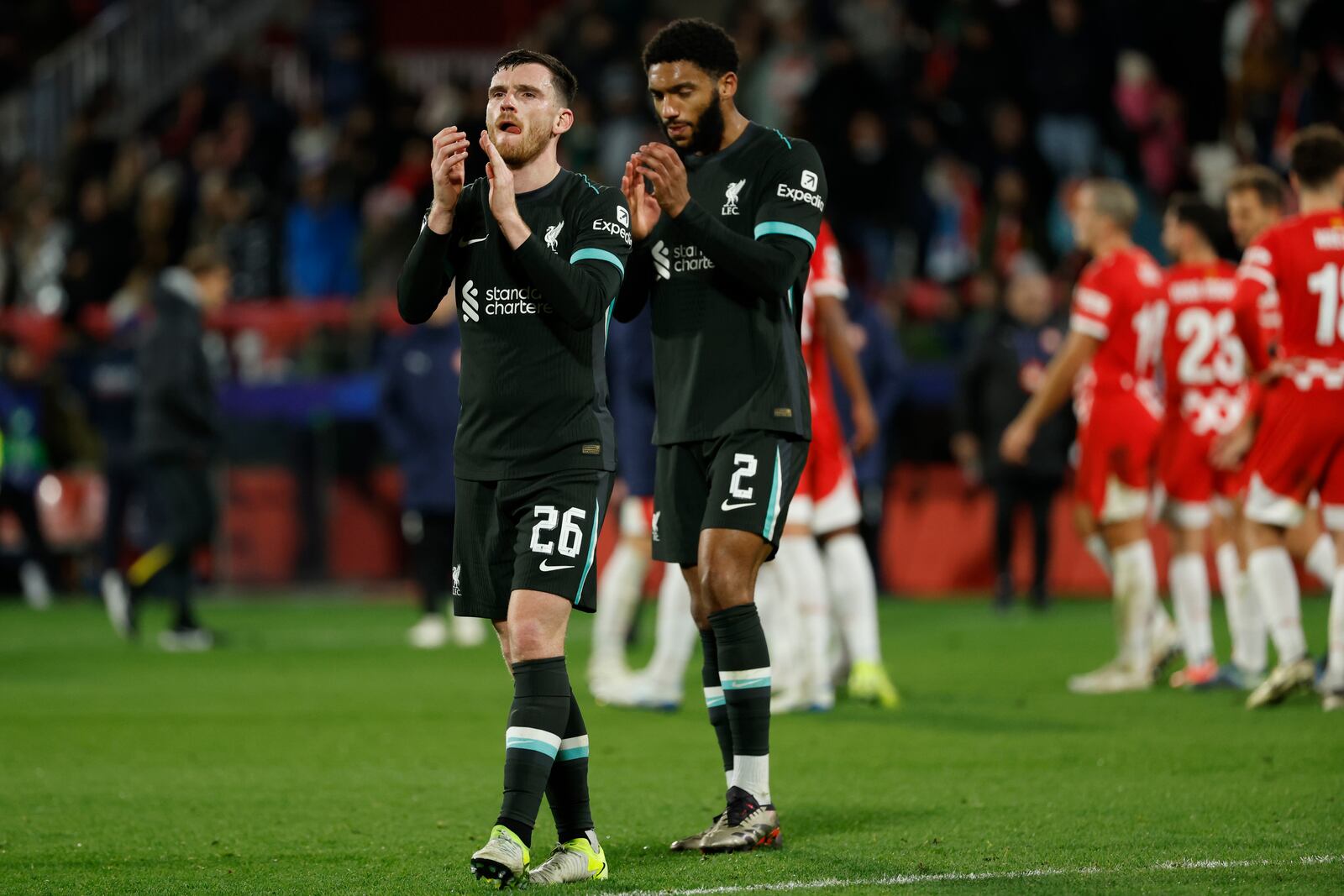 Liverpool's Andy Robertson, left, and Joe Gomez celebrate after their win in the Champions League soccer match against Girona at the Estadi Montilivi in Girona, Spain, Tuesday, Dec. 10, 2024. (AP Photo/Joan Monfort)