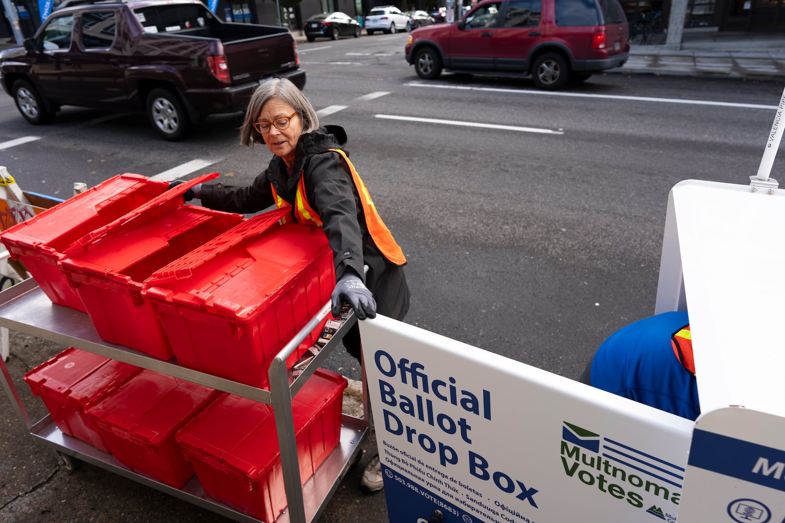 Election workers collect ballots from a newly placed ballot drop box outside the Multnomah County Elections Division office on Monday, Oct. 28, 2024, in Portland, Ore. (AP Photo/Jenny Kane)