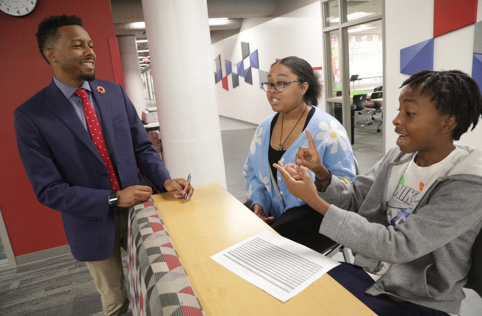 DECA Superintendent David Taylor talks students Janiah McDaniel, a junior, and CJ Fields, a freshman at DECA High School Friday, August 26, 2022. BILL LACKEY/STAFF