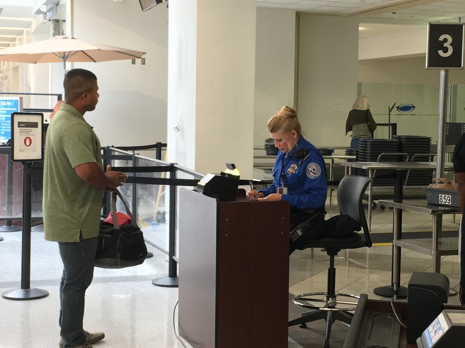 A TSA official checks the ID and boarding pass of a passenger. STAFF PHOTO / HOLLY SHIVELY