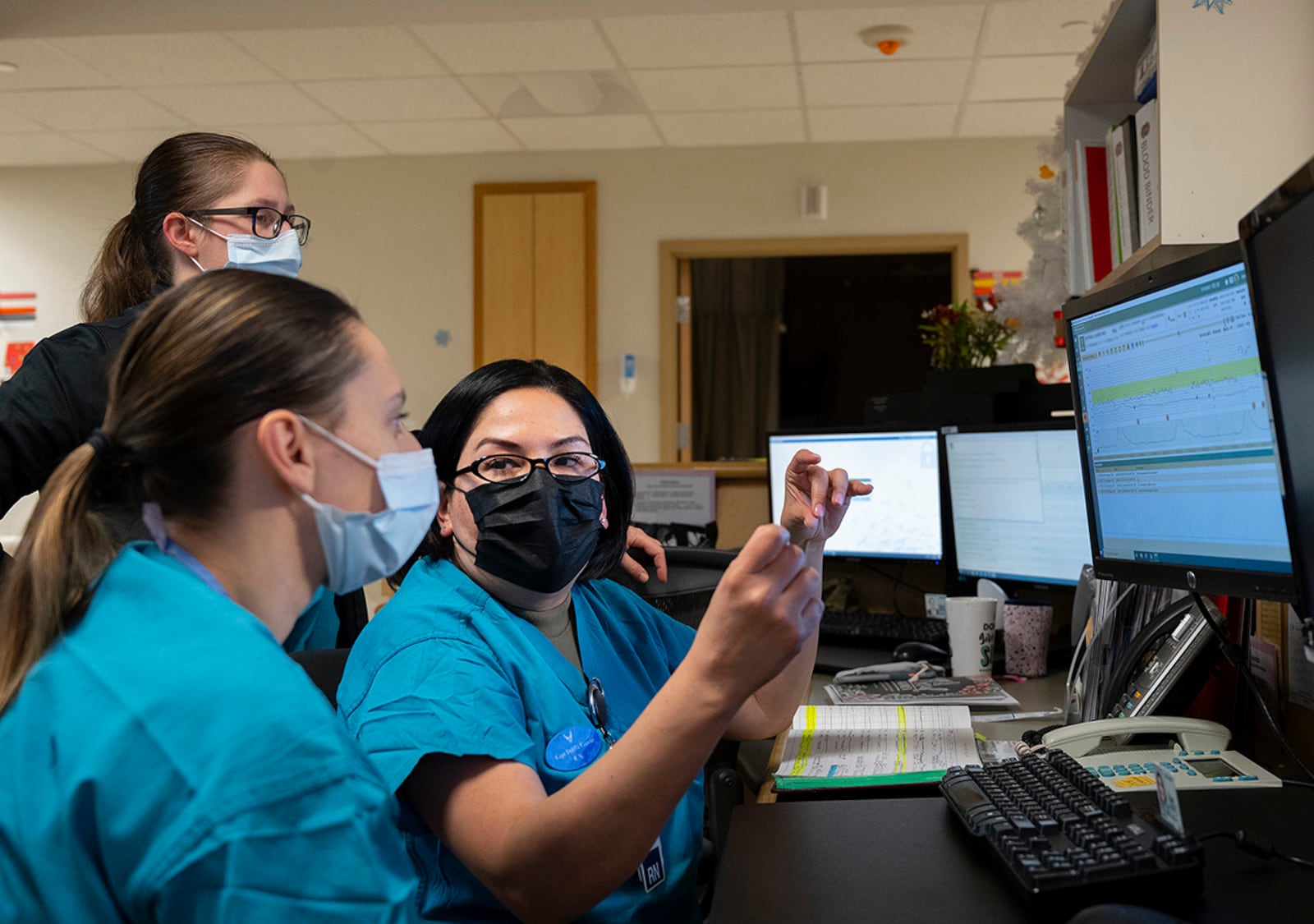 Capt. Dahlia Garcia (right), 88th Inpatient Operations Squadron charge nurse, works with 2nd Lt. Marjorie Zuber (foreground), a new Air Force nurse, at 5:20 a.m. during their Dec. 16 night shift at Wright-Patterson Medical Center’s Labor and Delivery Ward as Capt. Breanna Swartout looks on. Garcia called up some of the ward’s case histories to use as an example for things Zuber should look out for. (Part of the screen was blurred for privacy reasons). U.S. AIR FORCE PHOTO/R.J. ORIEZ