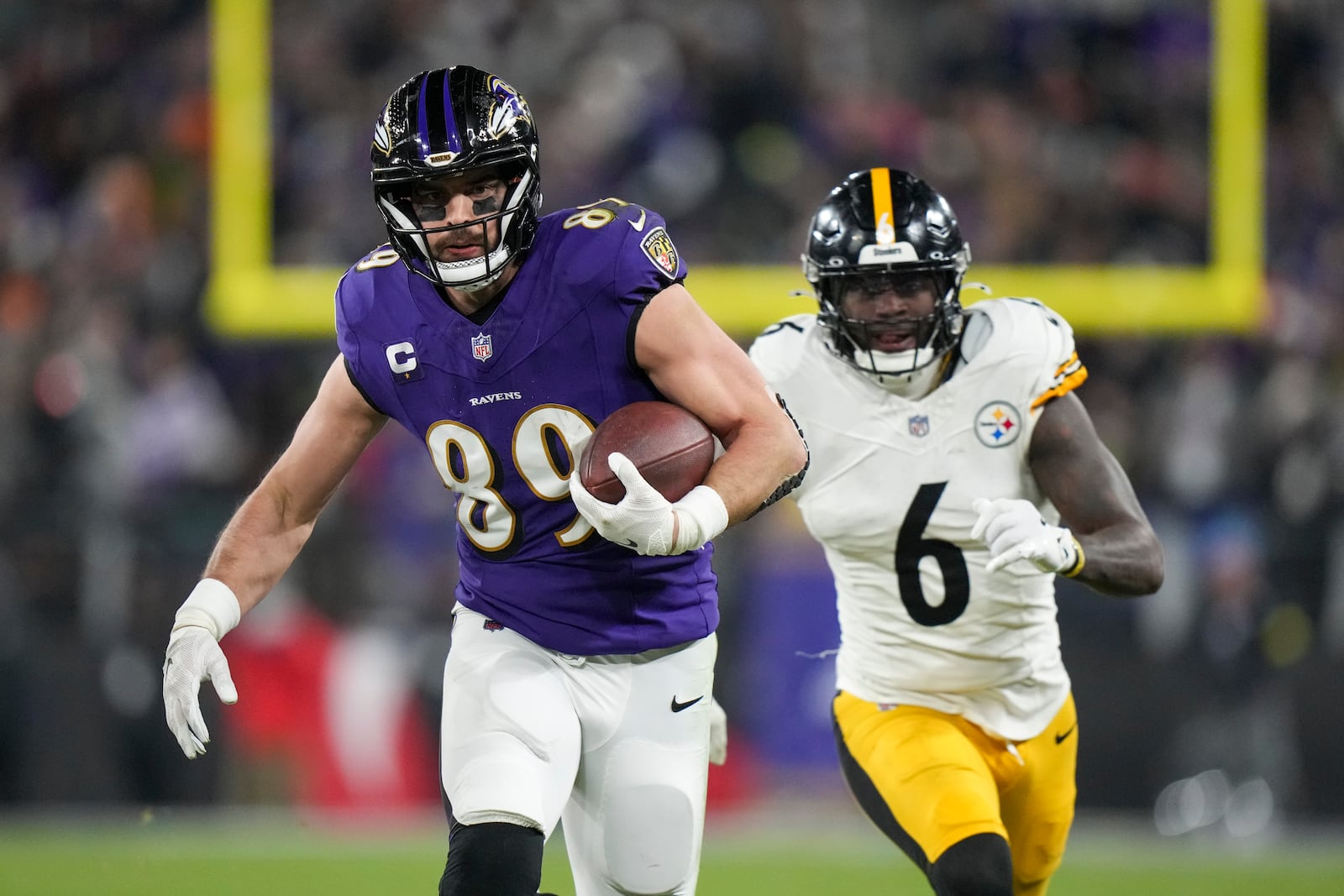 Baltimore Ravens tight end Mark Andrews runs after making a catch as Pittsburgh Steelers linebacker Patrick Queen (6) tries to stop him during the first half of an NFL wild-card playoff football game, Saturday, Jan. 11, 2025, in Baltimore. (AP Photo/Stephanie Scarbrough)