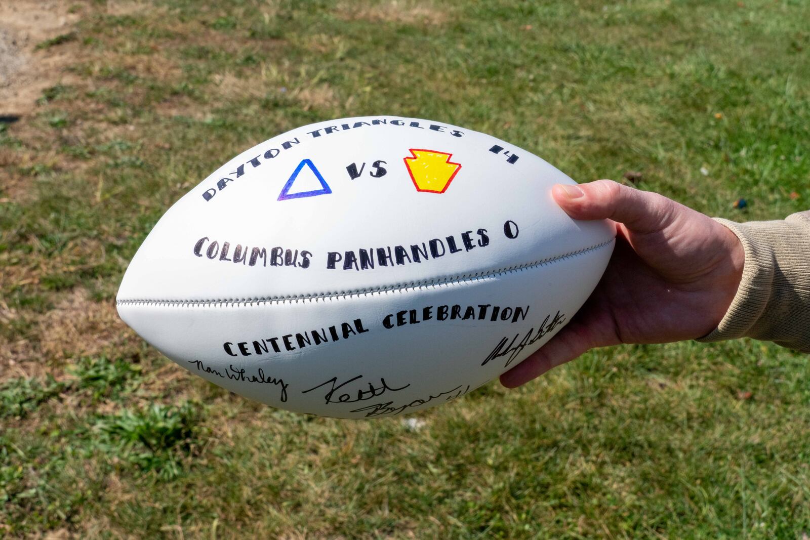 A football signed by Ohio NFL legend Keith Byars, Mayor Nan Whaley and Columbus Mayor Andy Ginther to commemorate the centennial anniversary of the first NFL game was presented to Ginther by Whaley on Saturday. On Oct. 3, 1920, the Dayton Triangles beat the Columbus Panhandles 14-0.