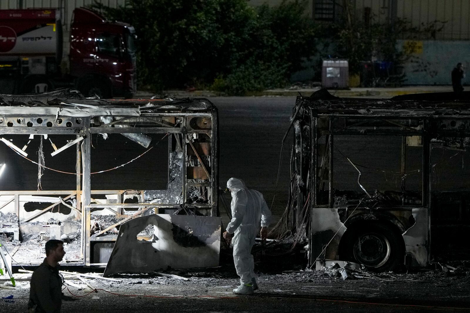 Israeli police inspect the scene of one of a series of bus explosions in what authorities said appeared to be a militant attack in Bat Yam, central Israel, Thursday, Feb. 20, 2025. (AP Photo/Ohad Zwigenberg)